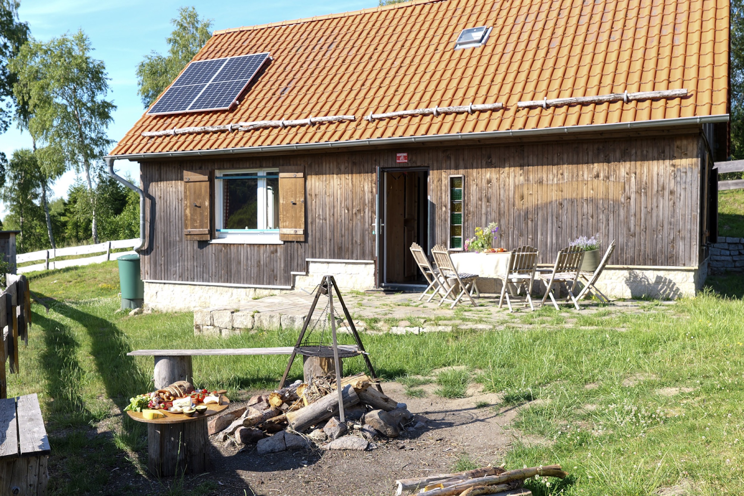 bergwacht aussenansicht mit feuerstelle und grillrost
