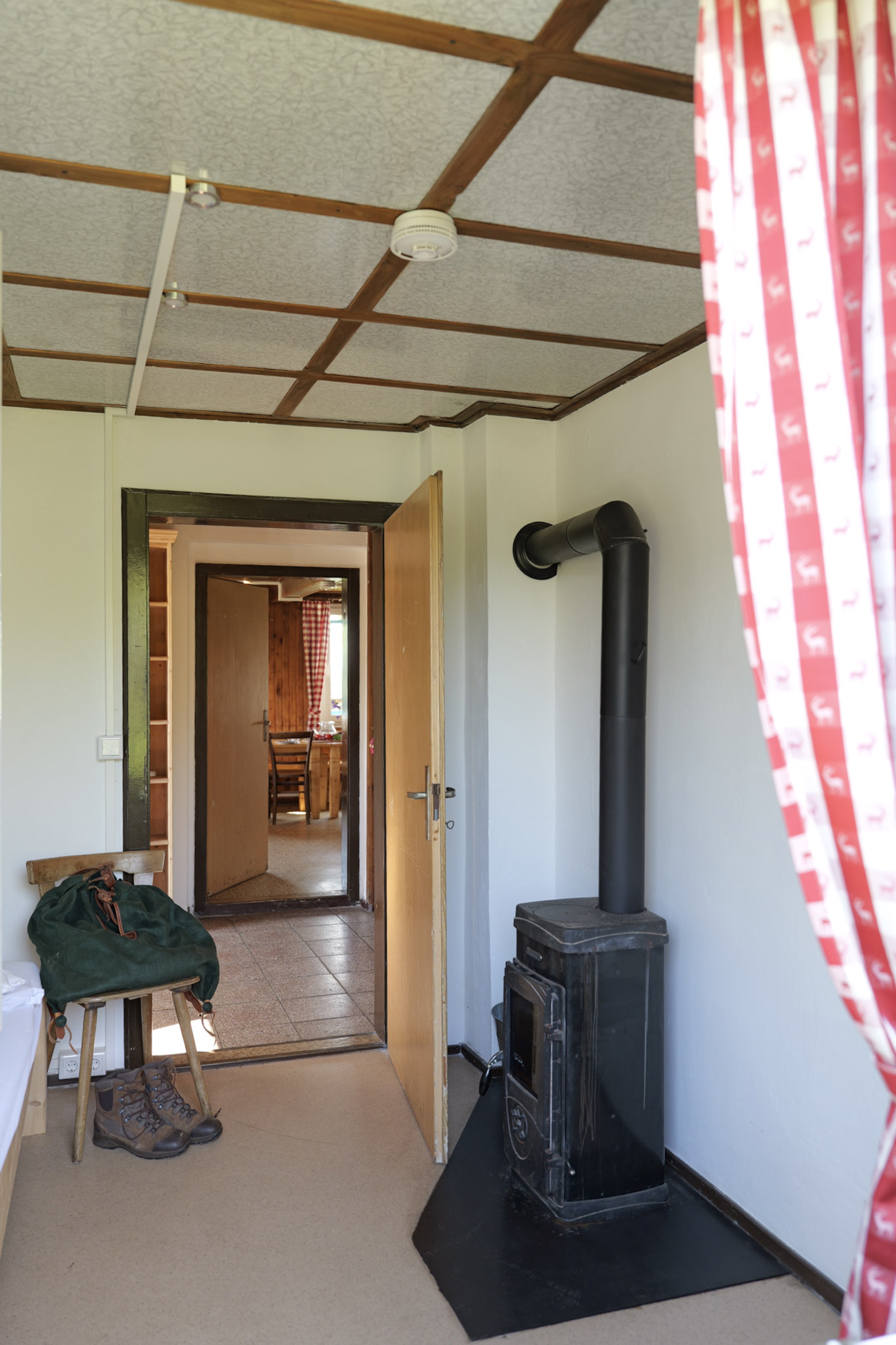 bergwacht-eingangsbereich-mit-holzofen-und-hirschvorhang