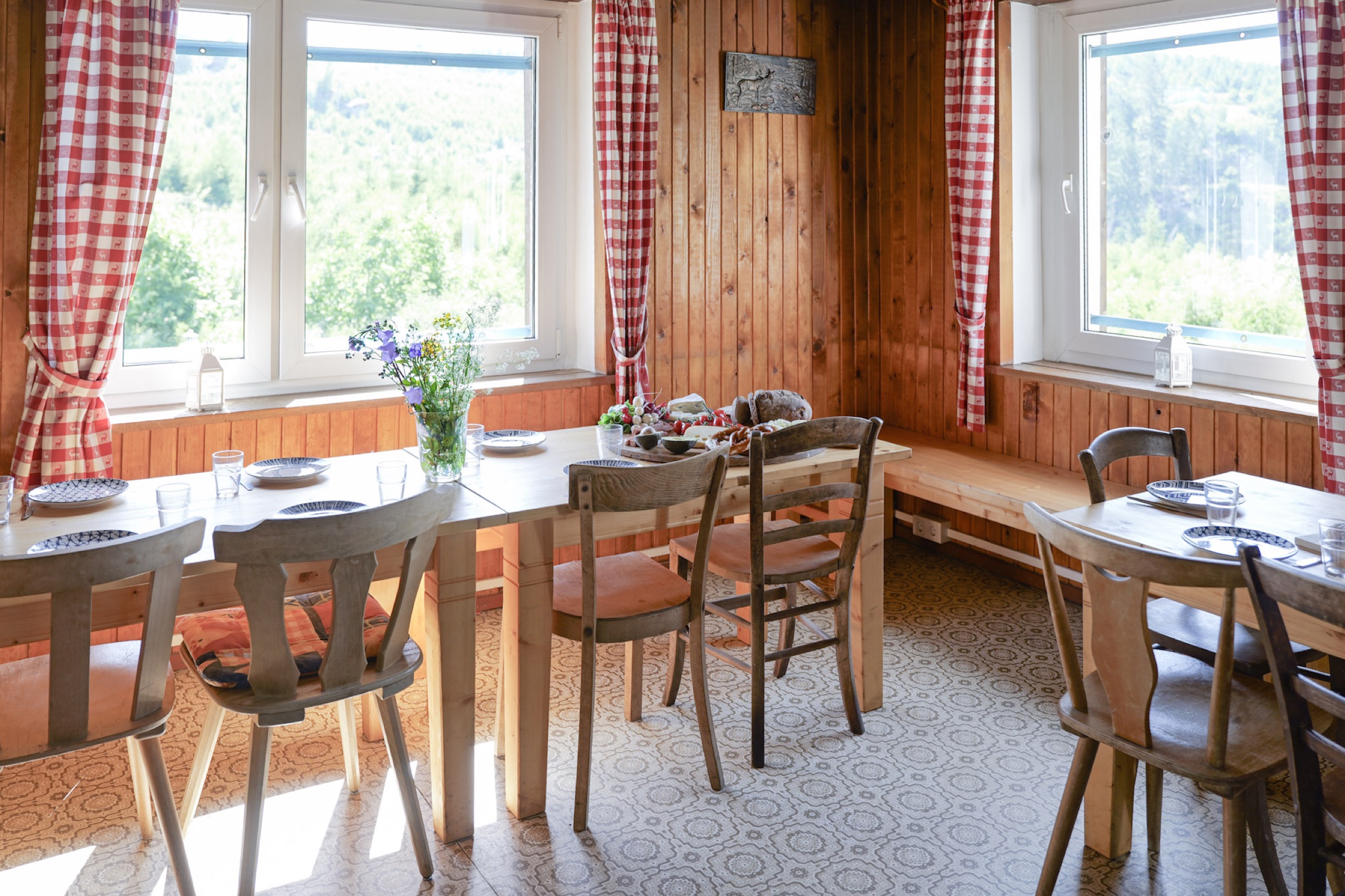 bergwacht esszimmer mit gedeckten tischen und waldblick