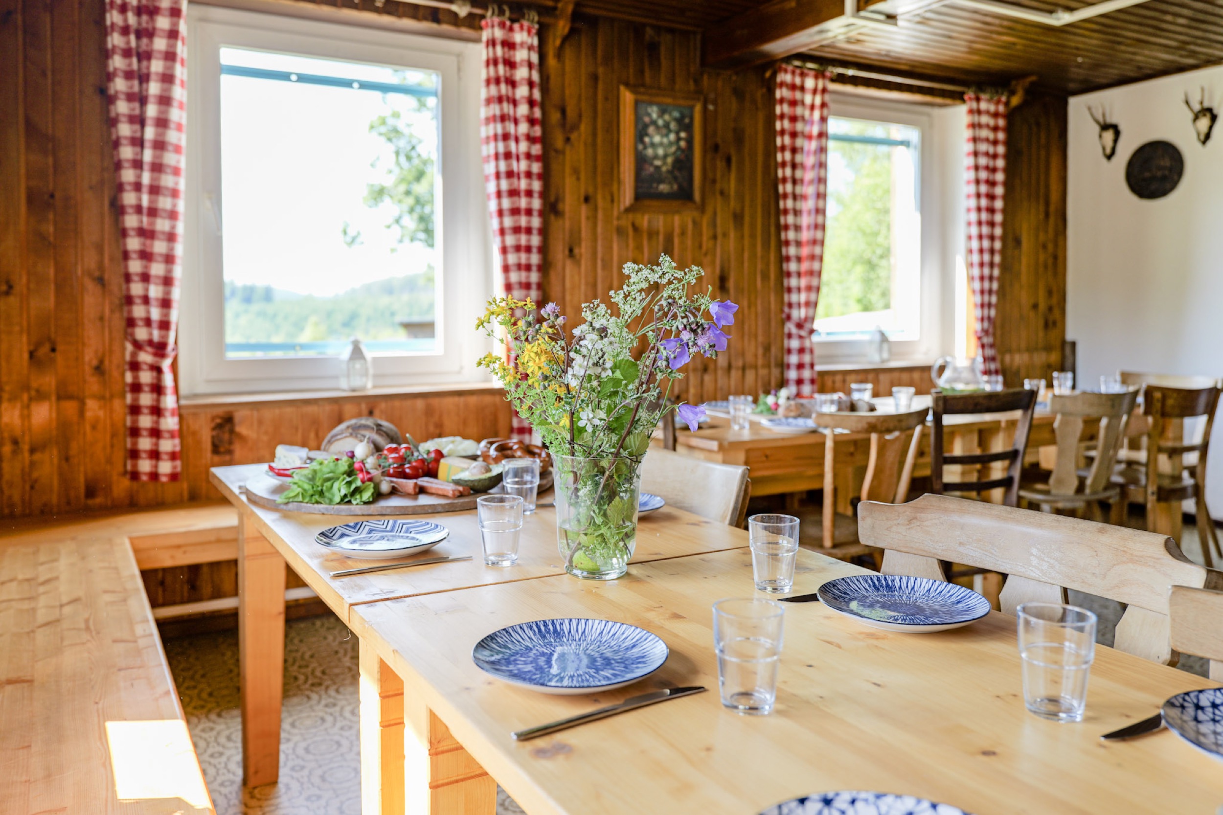 bergwacht esszimmer tisch mit blumenstrauss und geweihtrophaeen
