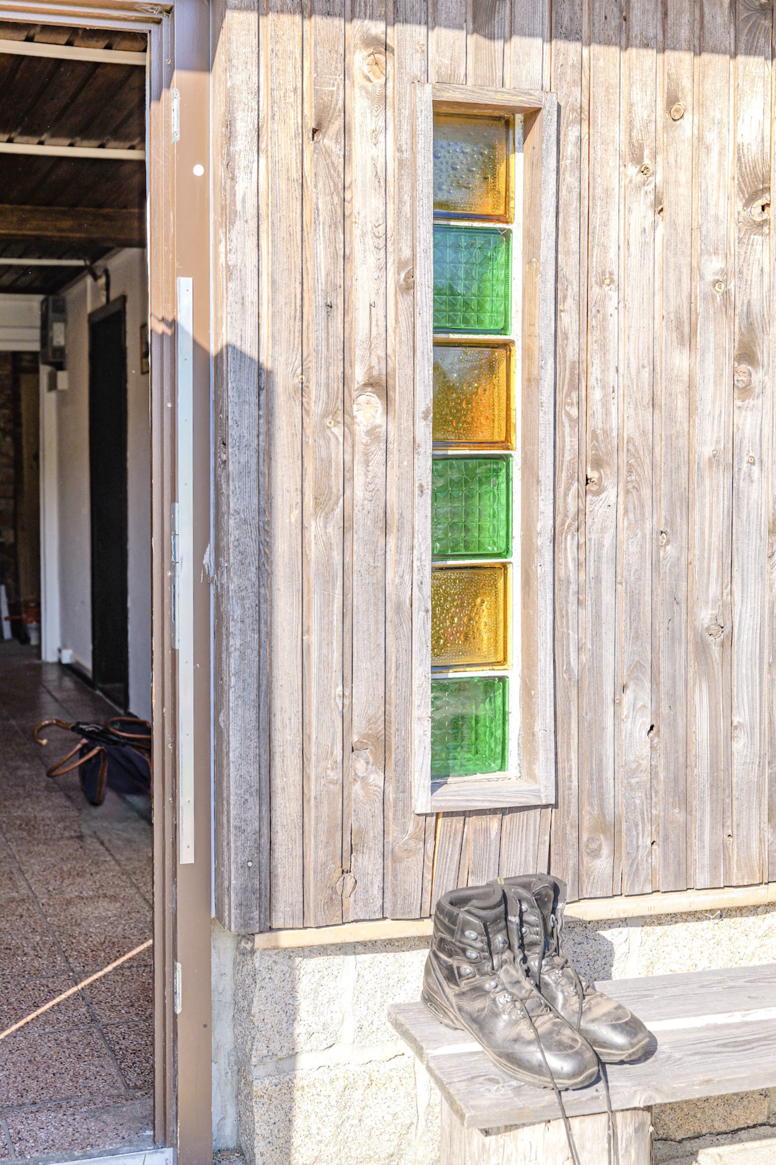 bergwacht-glasbausteinfenster-mit-wanderschuhen-auf-bank