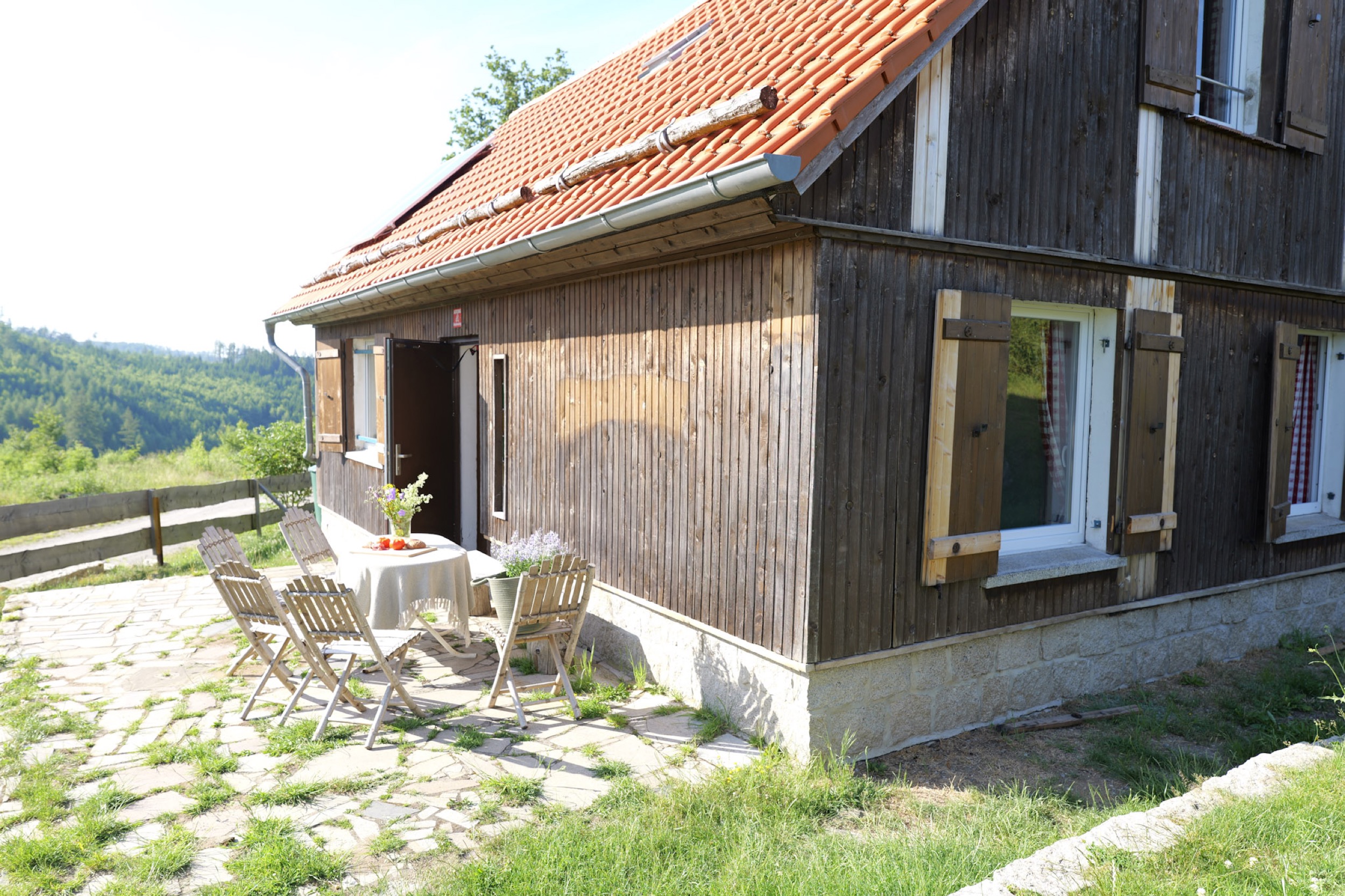 bergwacht hauseingang mit offener tuer und gartentisch