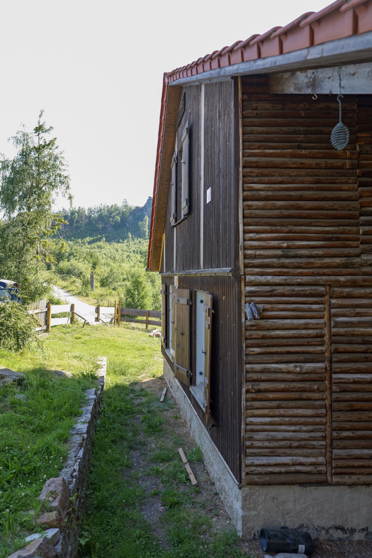 bergwacht-hausseite-mit-blick-auf-wald-und-felsen