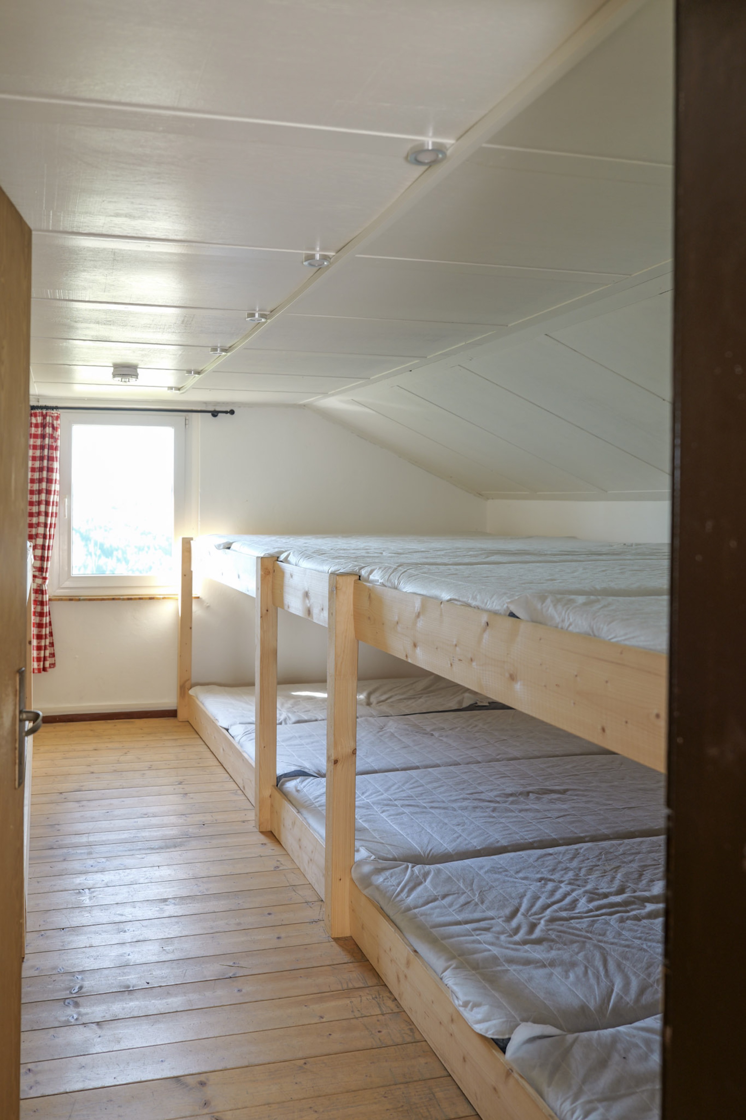 bergwacht-mehrbettzimmer-hochbetten-tuer-zum-flur