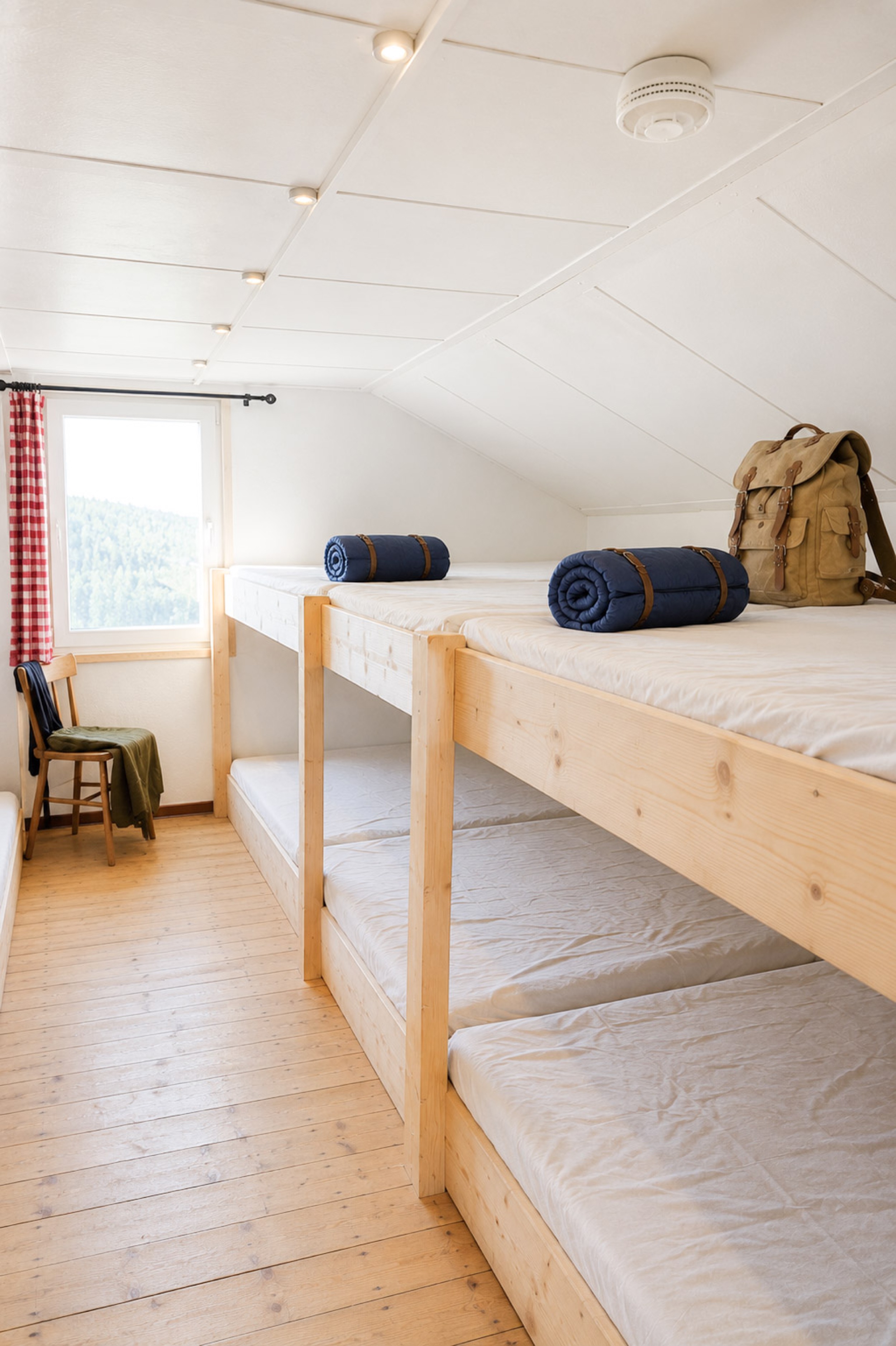 bergwacht-mehrbettzimmer-holzbetten-mit-rucksack-und-schlafsack