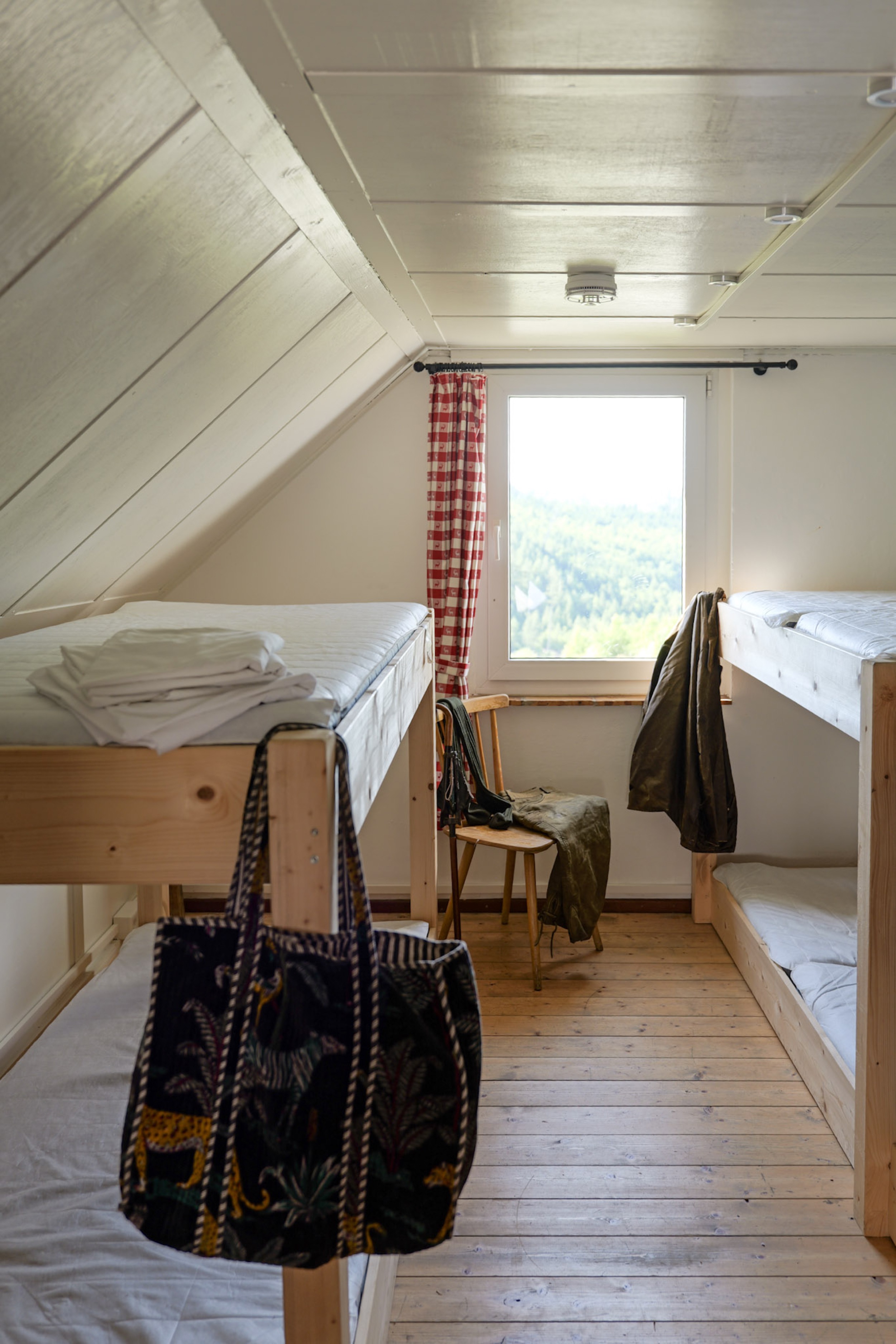 bergwacht-mehrbettzimmer-stuhl-mit-jacken-am-fenster