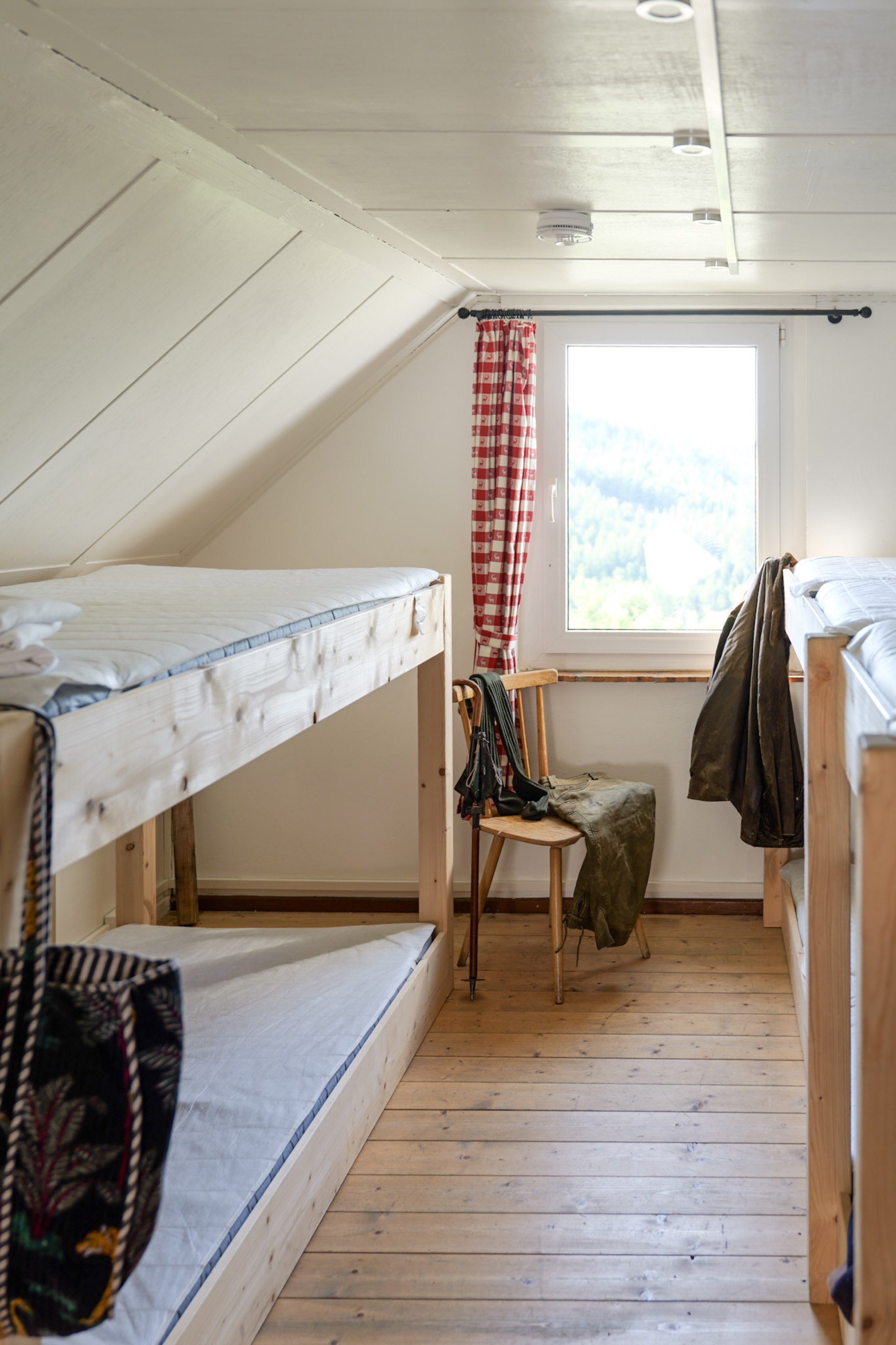 bergwacht-mehrbettzimmer-stuhl-mit-rucksackgurten-am-fenster