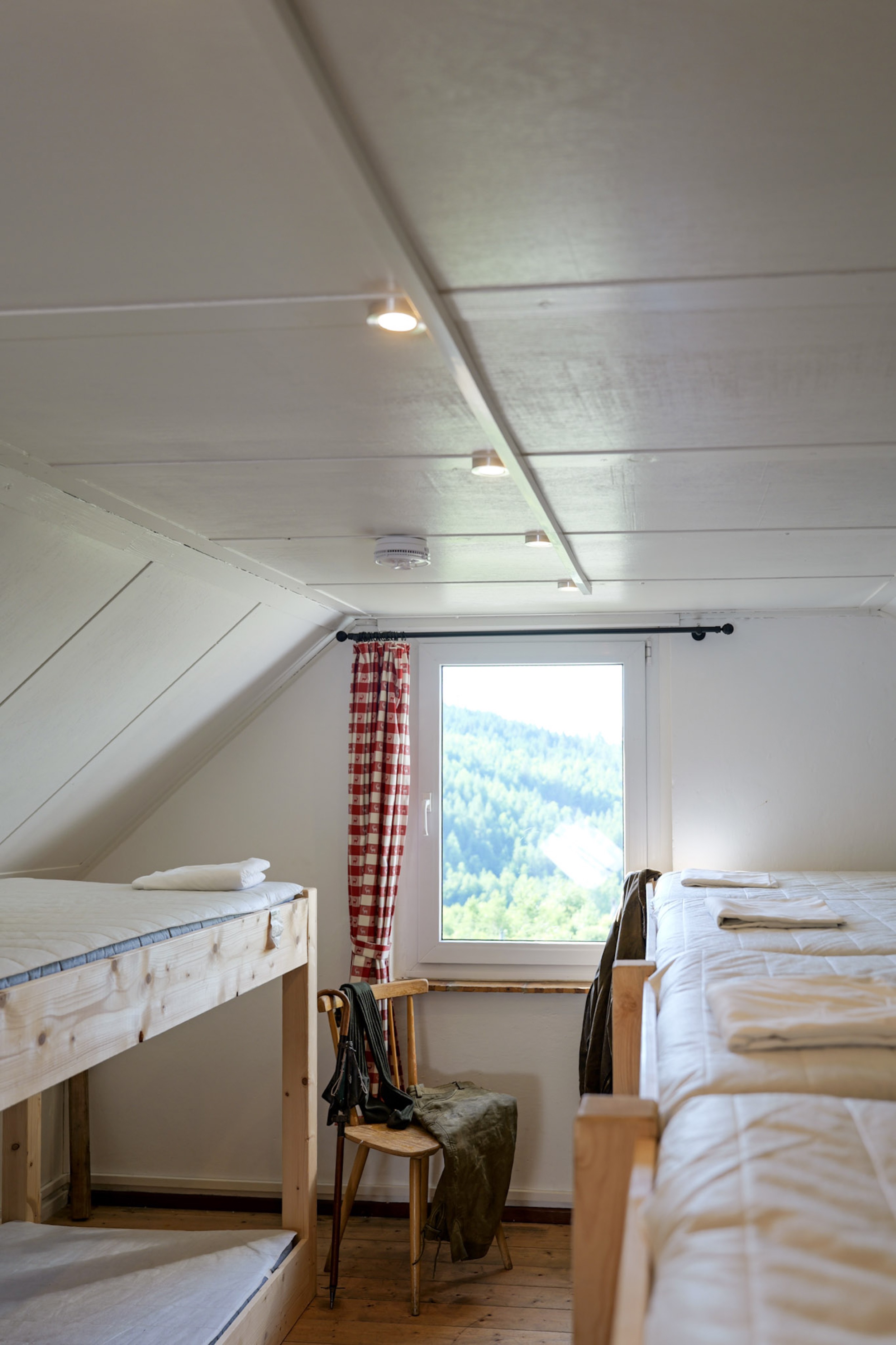 bergwacht-mehrbettzimmer-weitwinkel-mit-fensterblick-auf-huegel