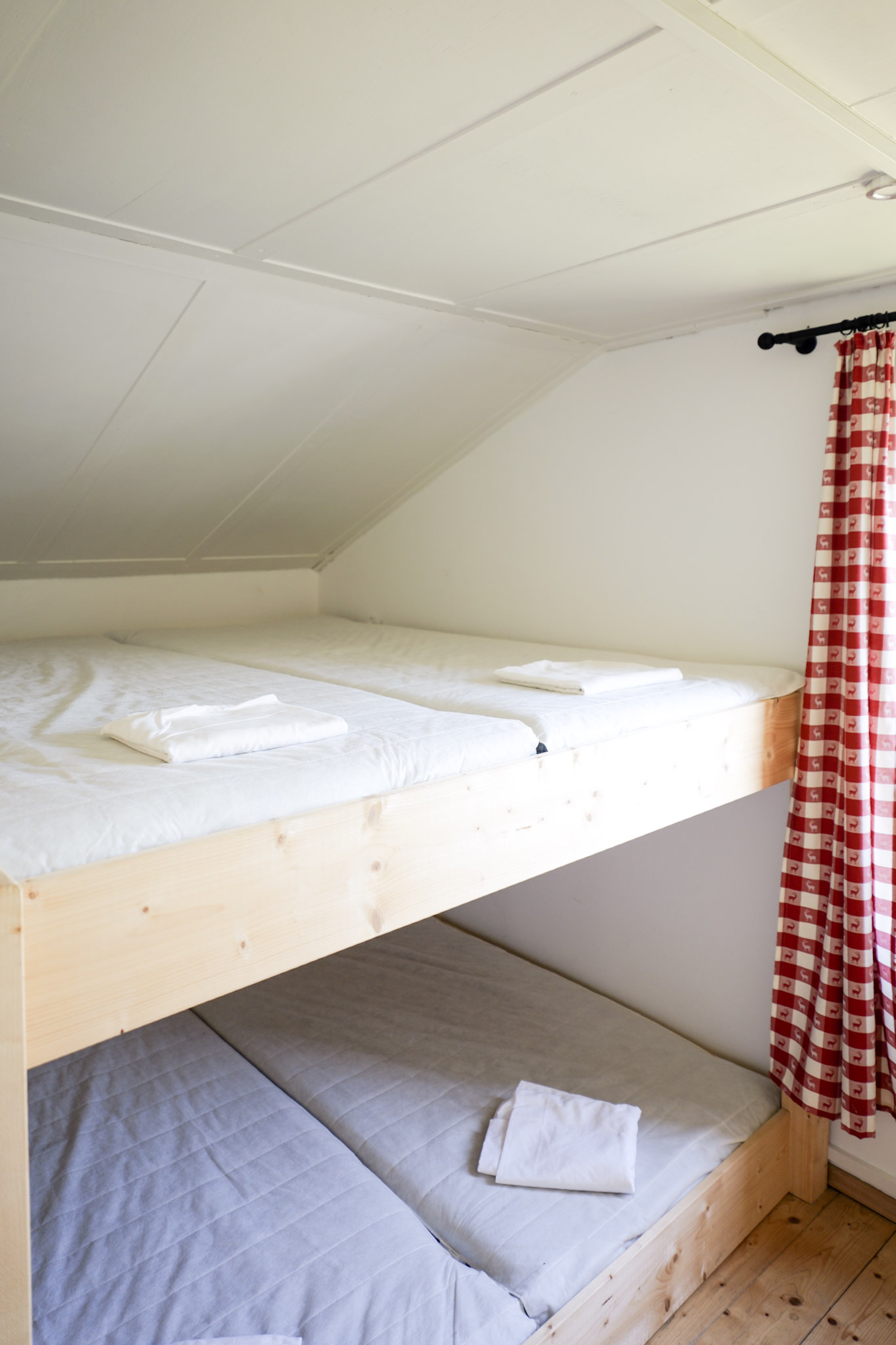bergwacht-schlafsaal-stockbett-gefaltete-handtuecher-kariertem-vorhang