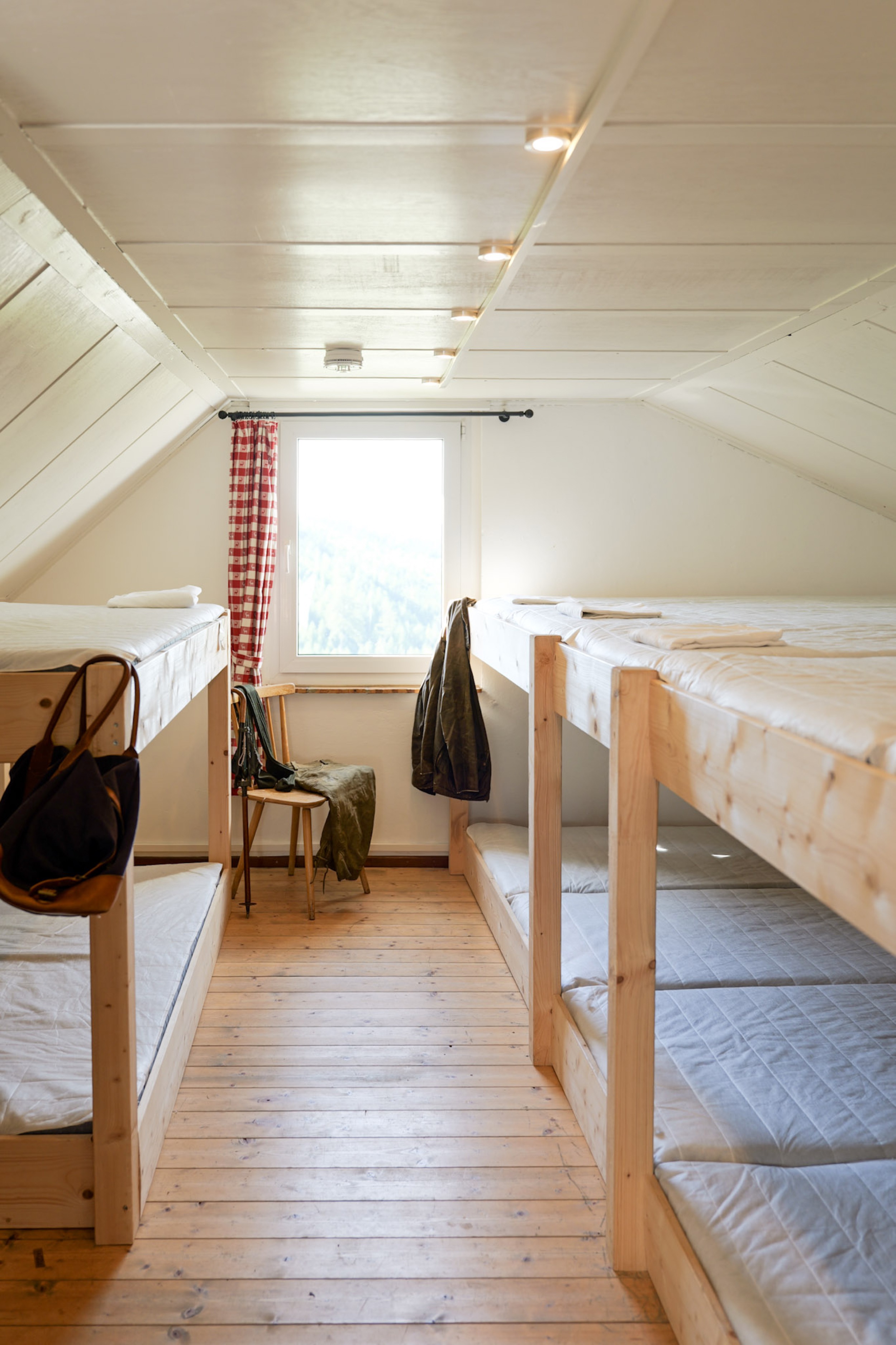 bergwacht-schlafsaal-stockbetten-tuerblick-mit-reisetasche