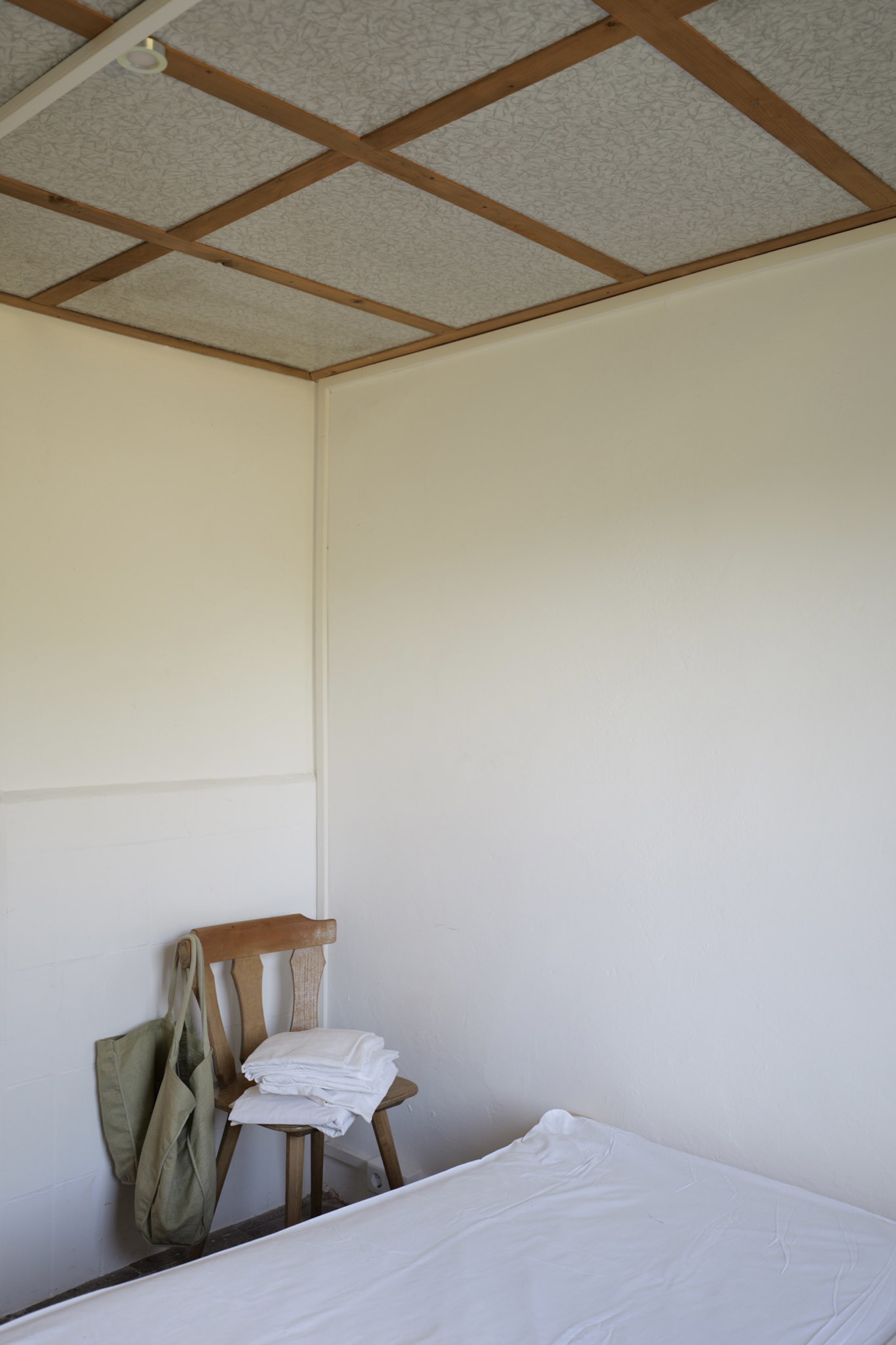 bergwacht-schlafzimmer-ecke-mit-stuhl-und-gefalteter-bettwaesche
