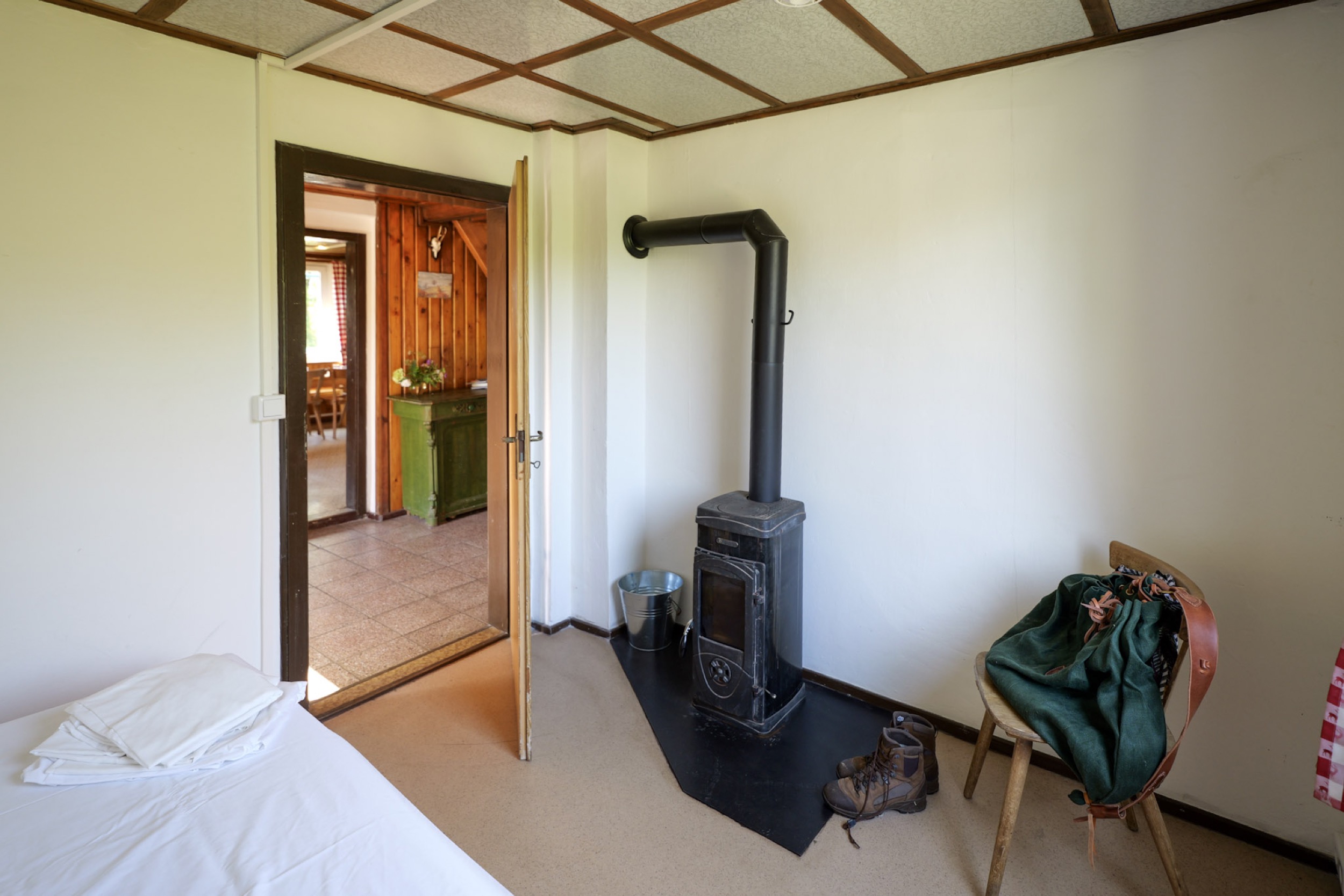 bergwacht schlafzimmer mit ofenrohr und blick zur diele