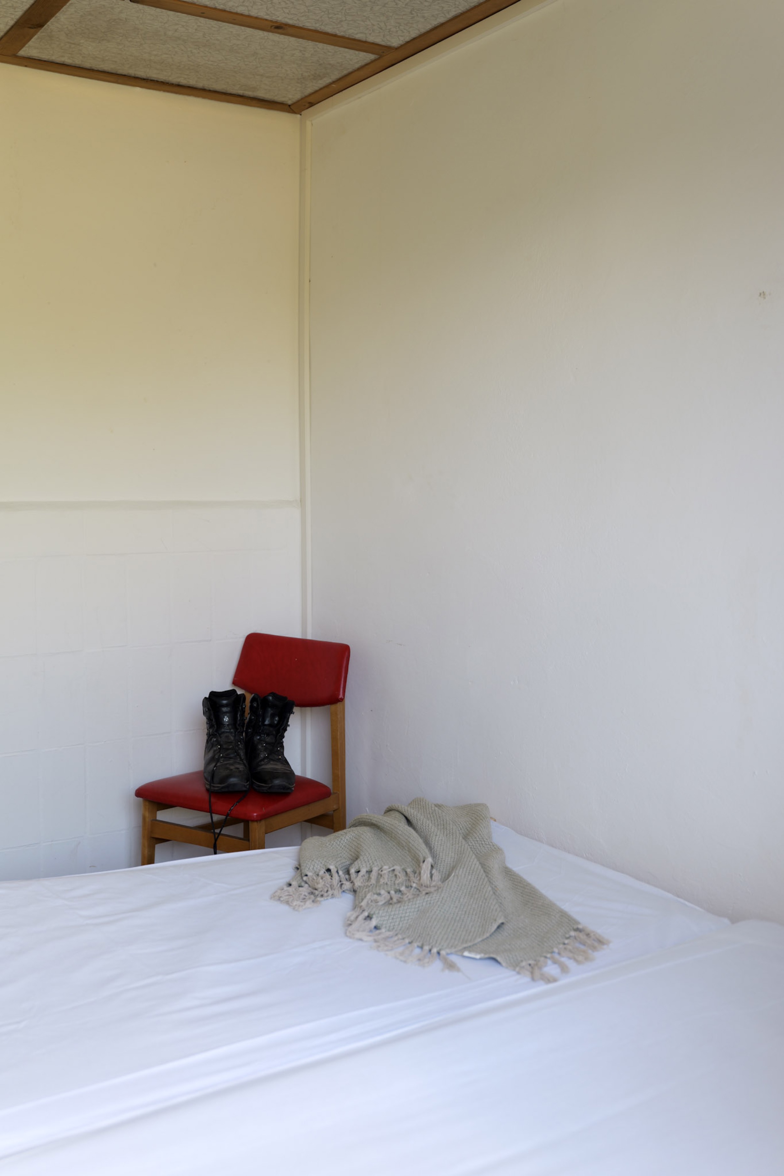 bergwacht-schlafzimmerecke-roter-stuhl-mit-wanderschuhen