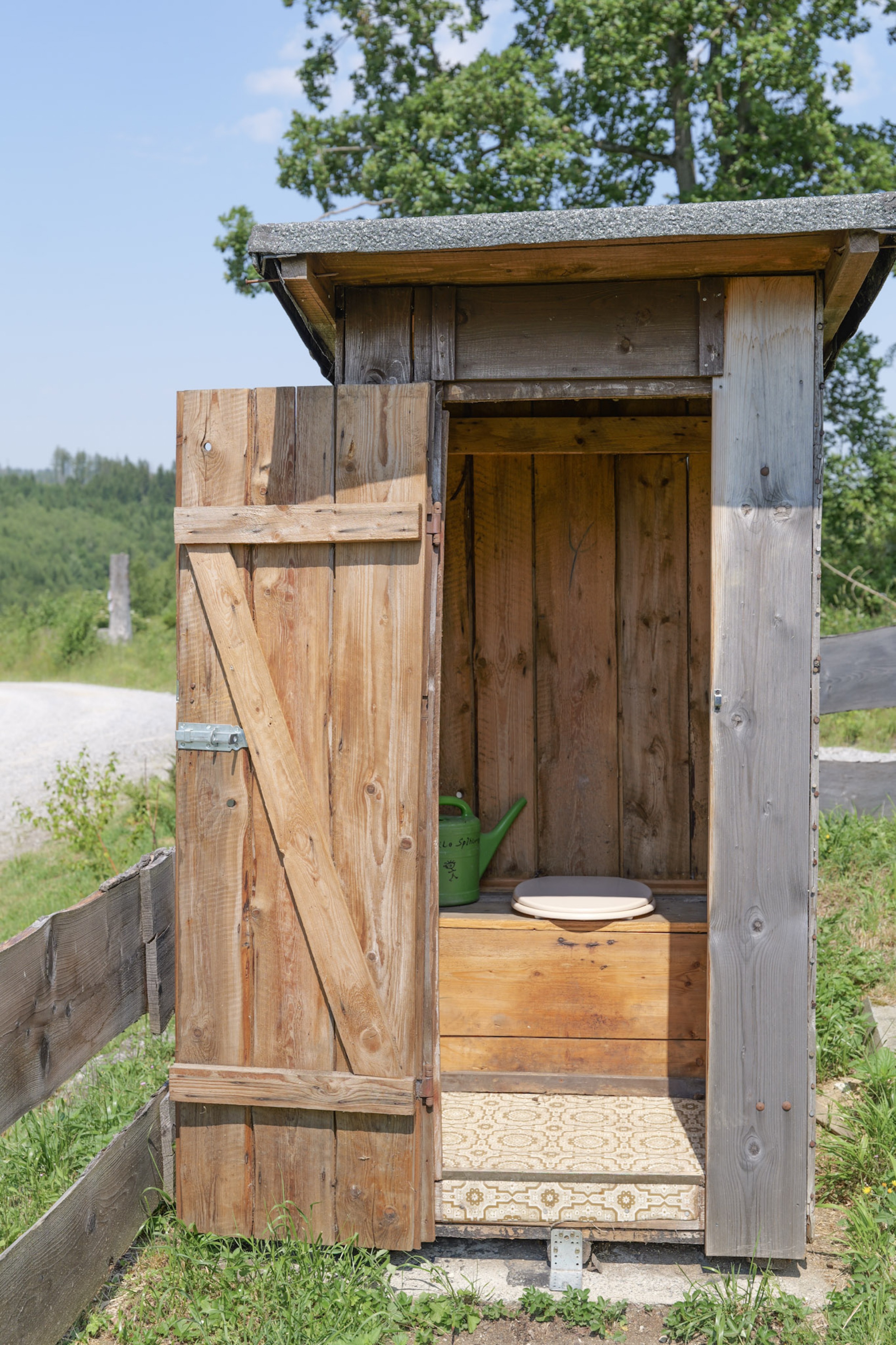 bergwacht-trockentoilette-holzhuette-am-zaun-blick-wald
