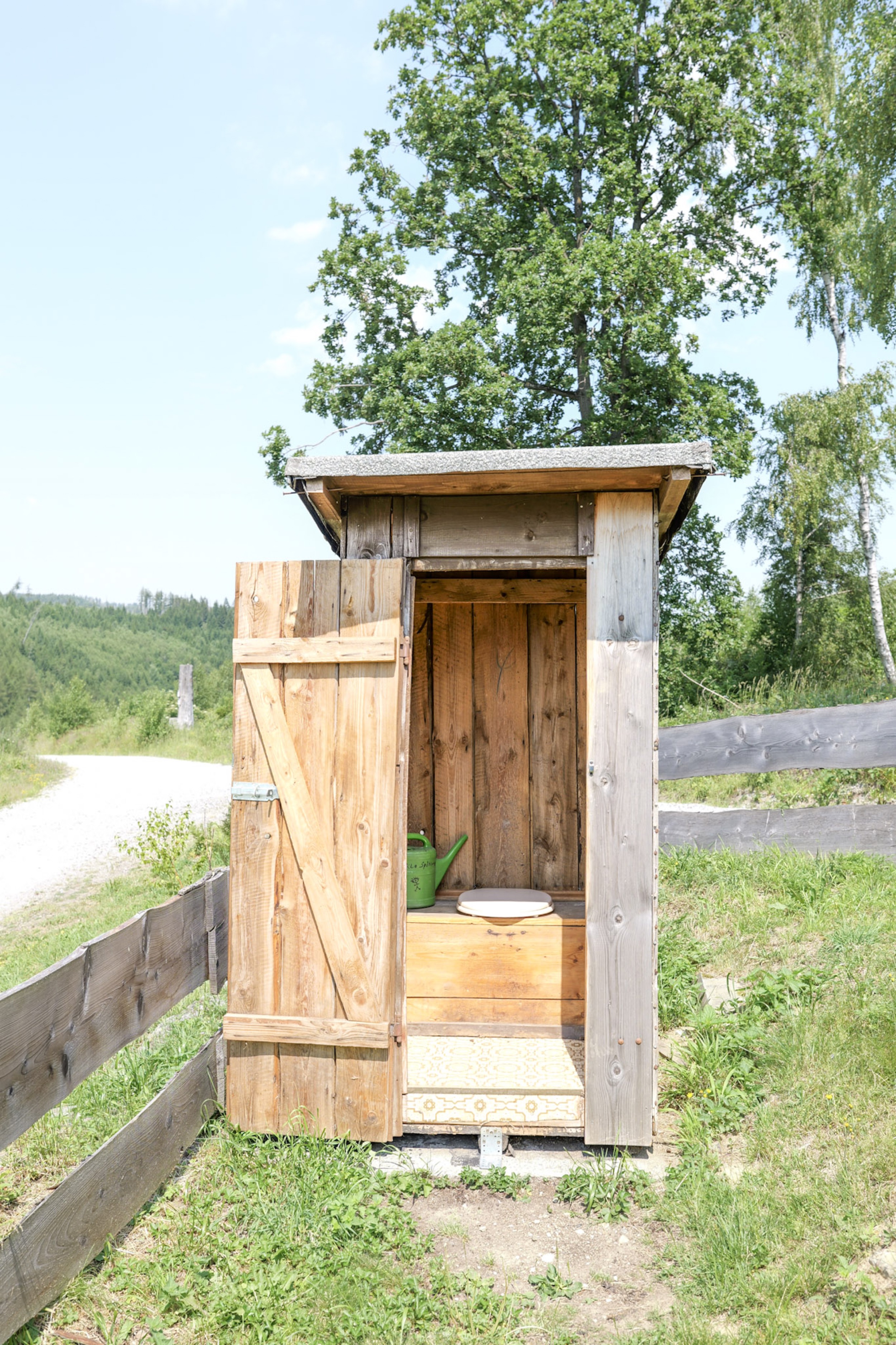 bergwacht-trockentoilette-holzhuette-offene-tuer-blick-huegel