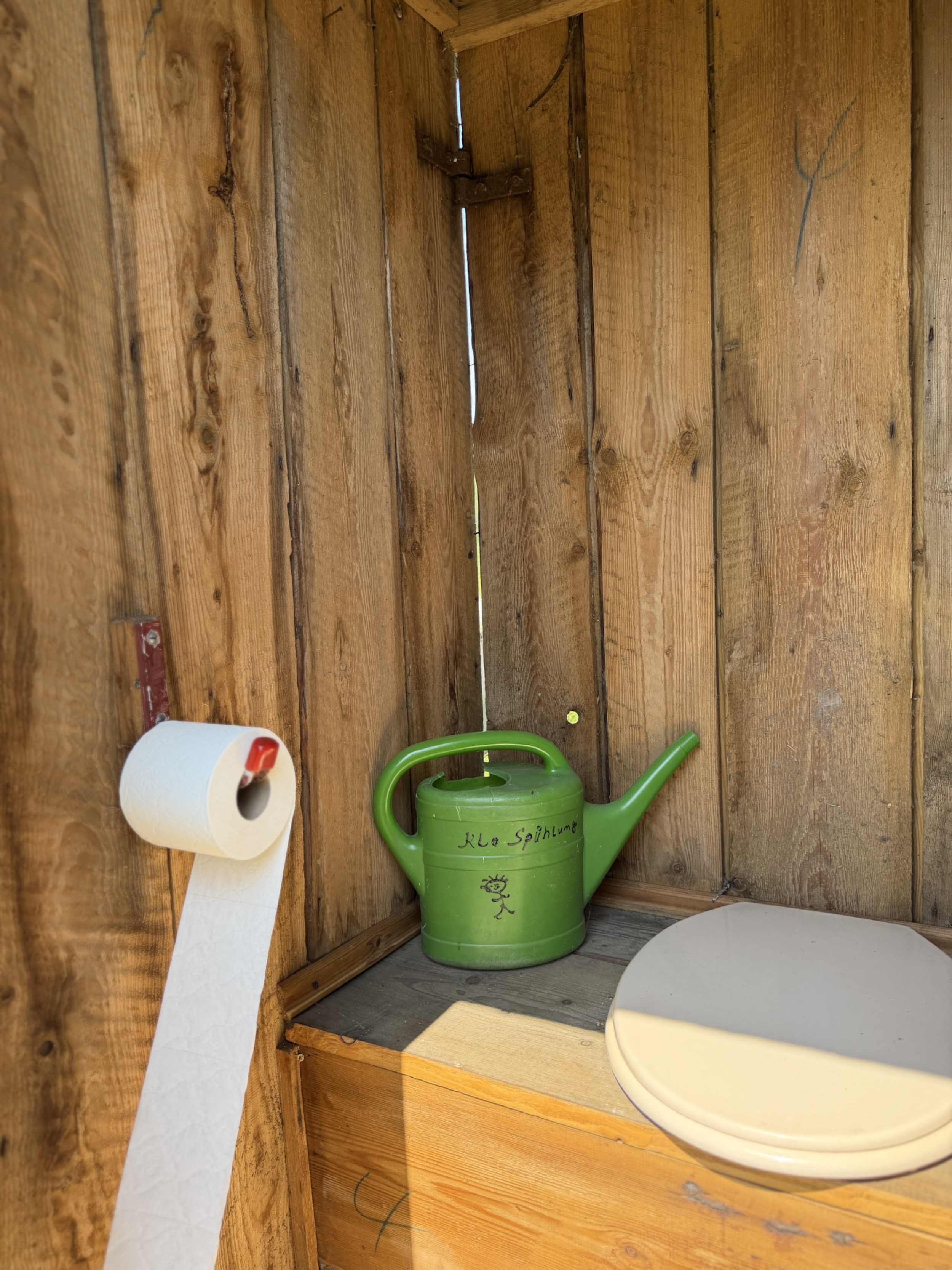bergwacht-trockentoilette-innenraum-gruene-giesskanne-toilettenpapier