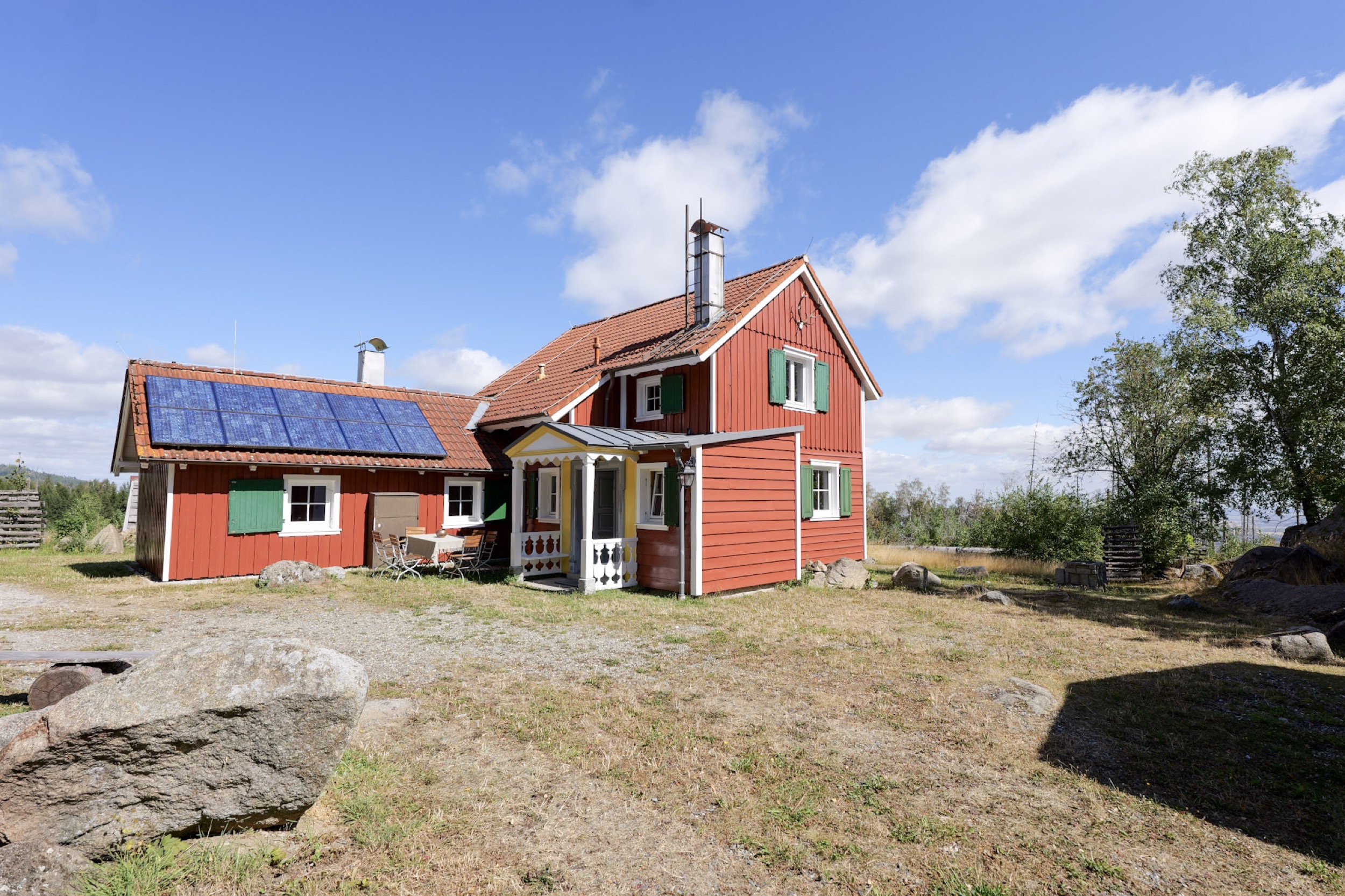 carlshaus ansicht von der trockenen wiese mit grossen findlingen im vordergrund