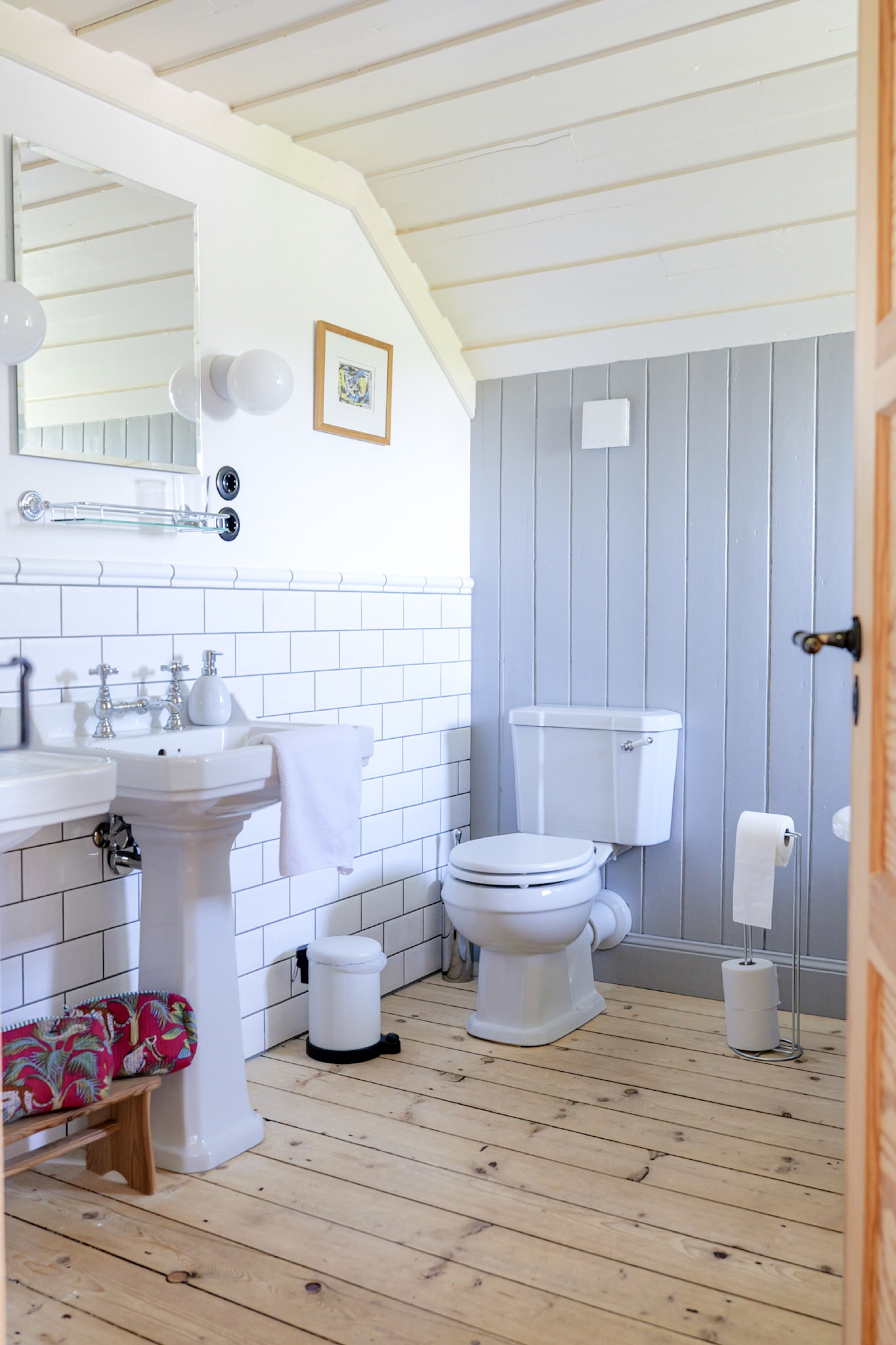 carlshaus-badezimmer-toilette-graue-vertaefelung-waschbecken-fliesen