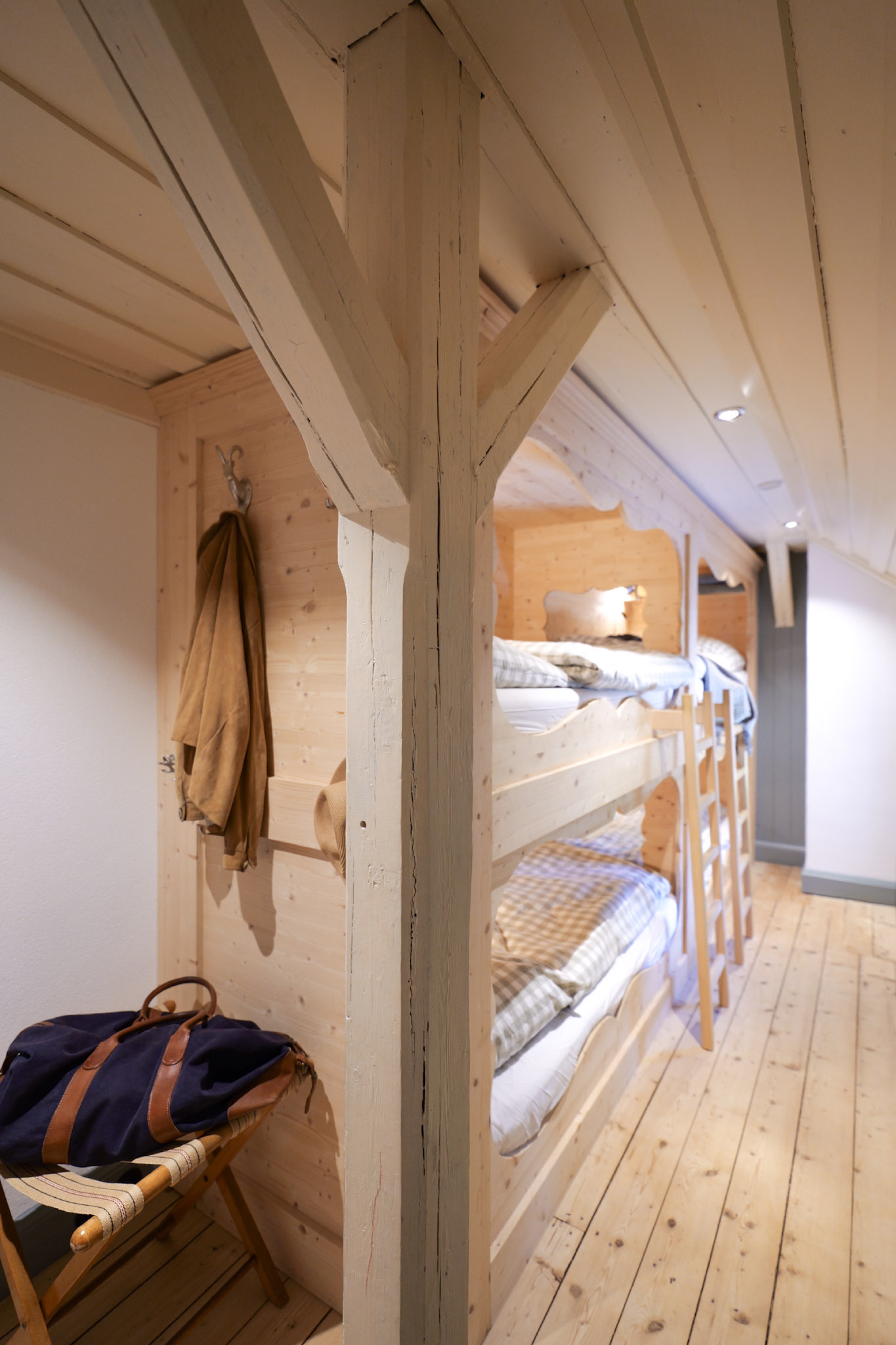 carlshaus-dachgeschoss-etagenbett-reisetasche-hocker-flur-holzbalken