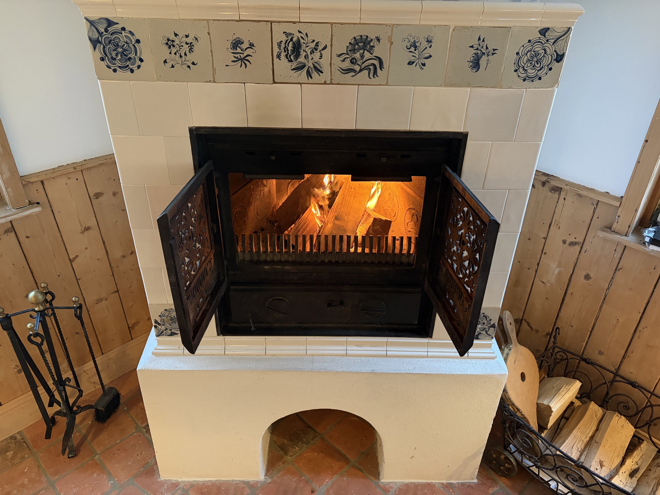 carlshaus harz kaminofen gesamtansicht mit feuerholz und kaminbesteck