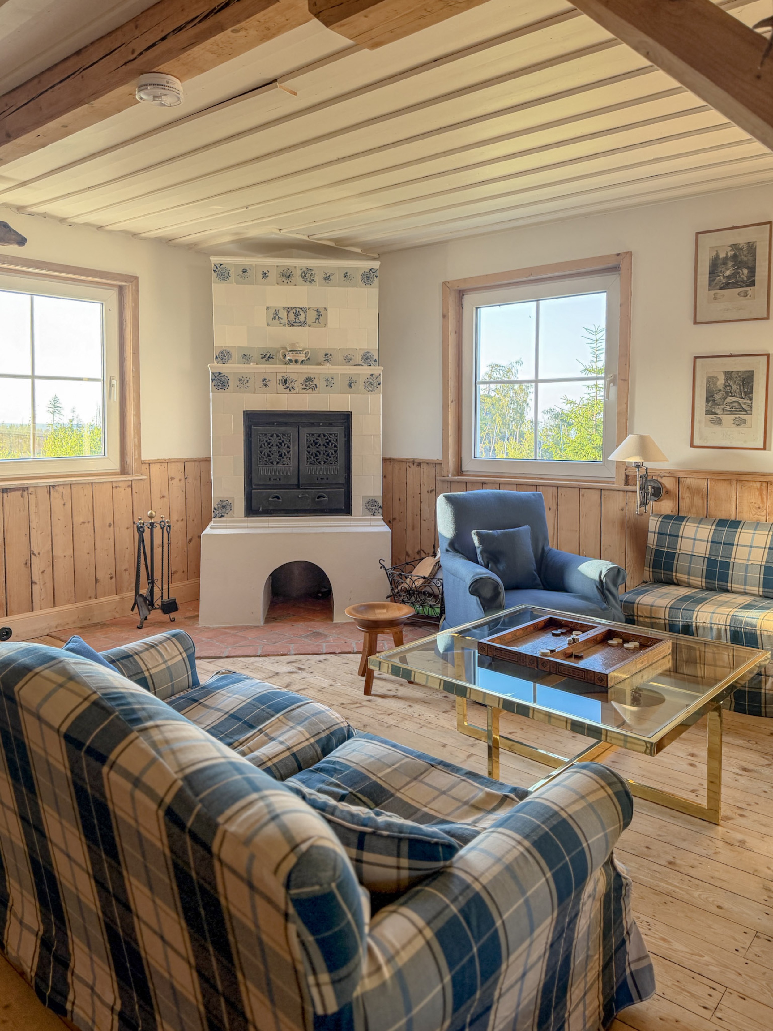 carlshaus-wohnzimmer-delfter-kachelofen-blaue-karierte-sofas-backgammontisch