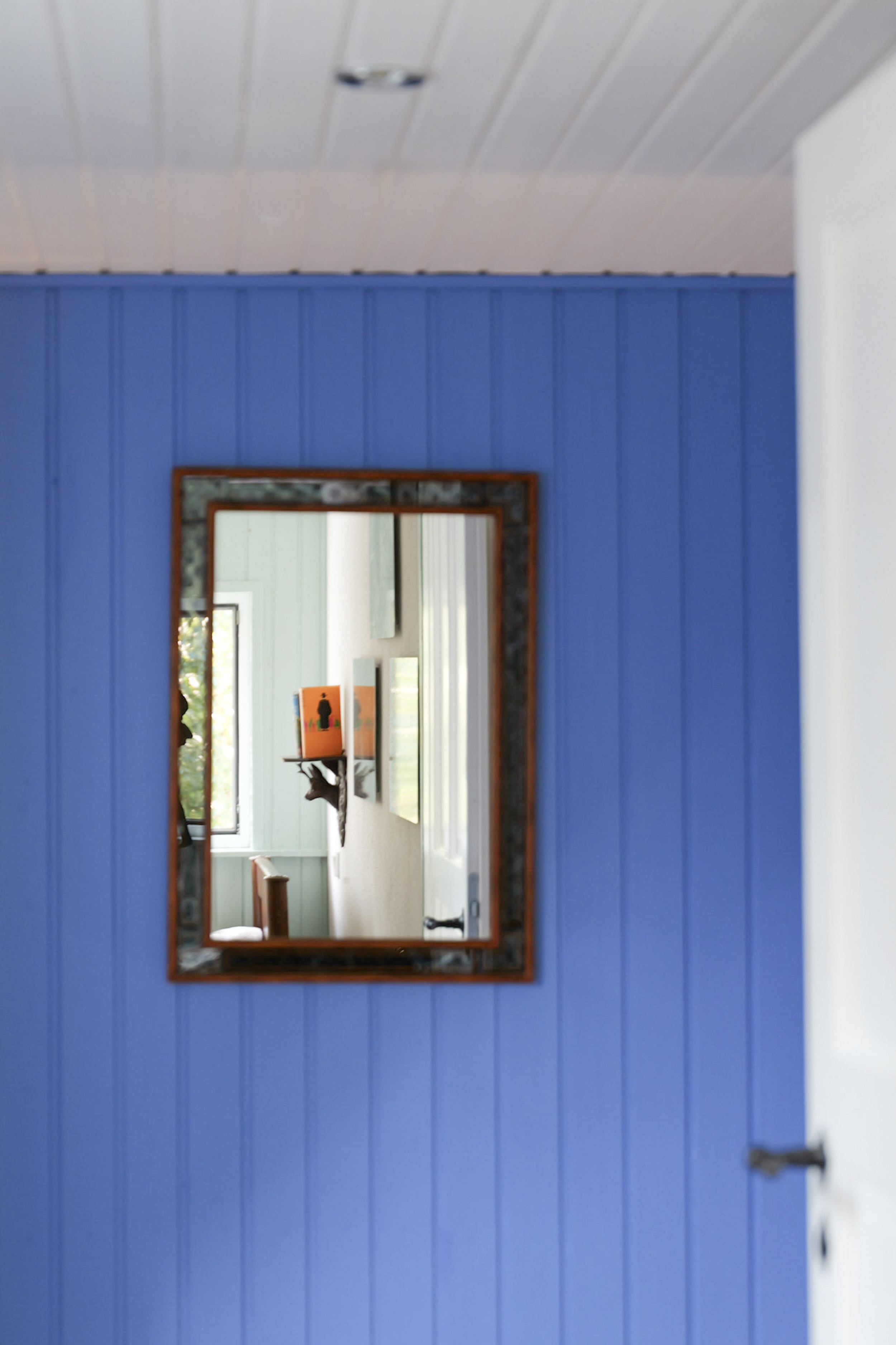 hexenhaus-antiker-spiegel-an-blauer-wand-mit-spiegelung-des-flurs