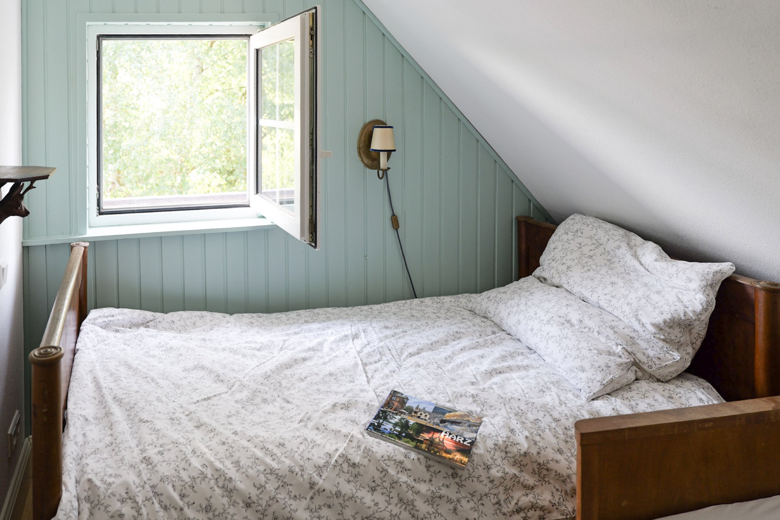hexenhaus bett am fenster mit harz reisefuehrer blick auf beide betten