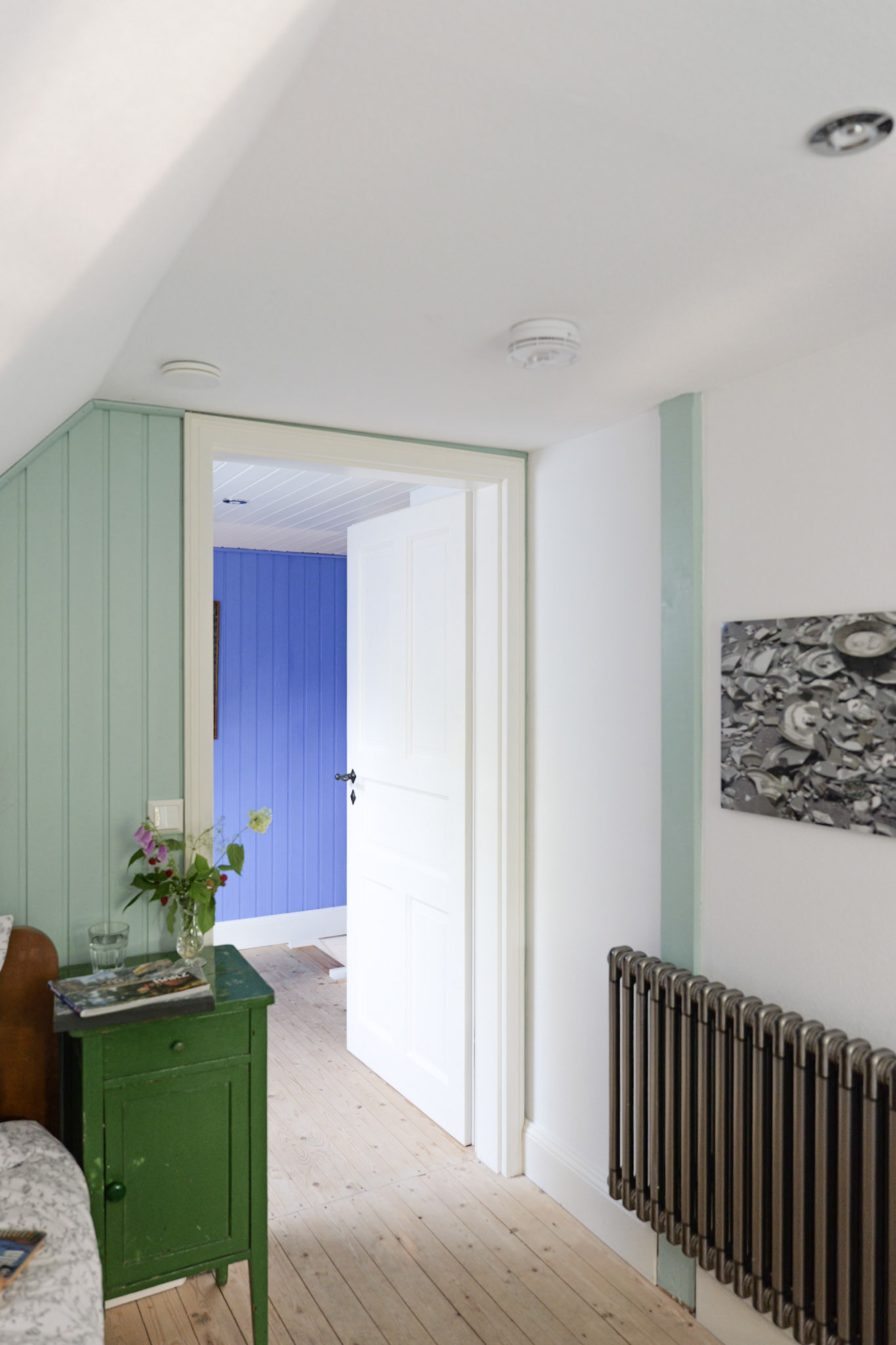 hexenhaus-flur-mit-blick-ins-blaue-zimmer-und-kunstwerk-an-der-wand