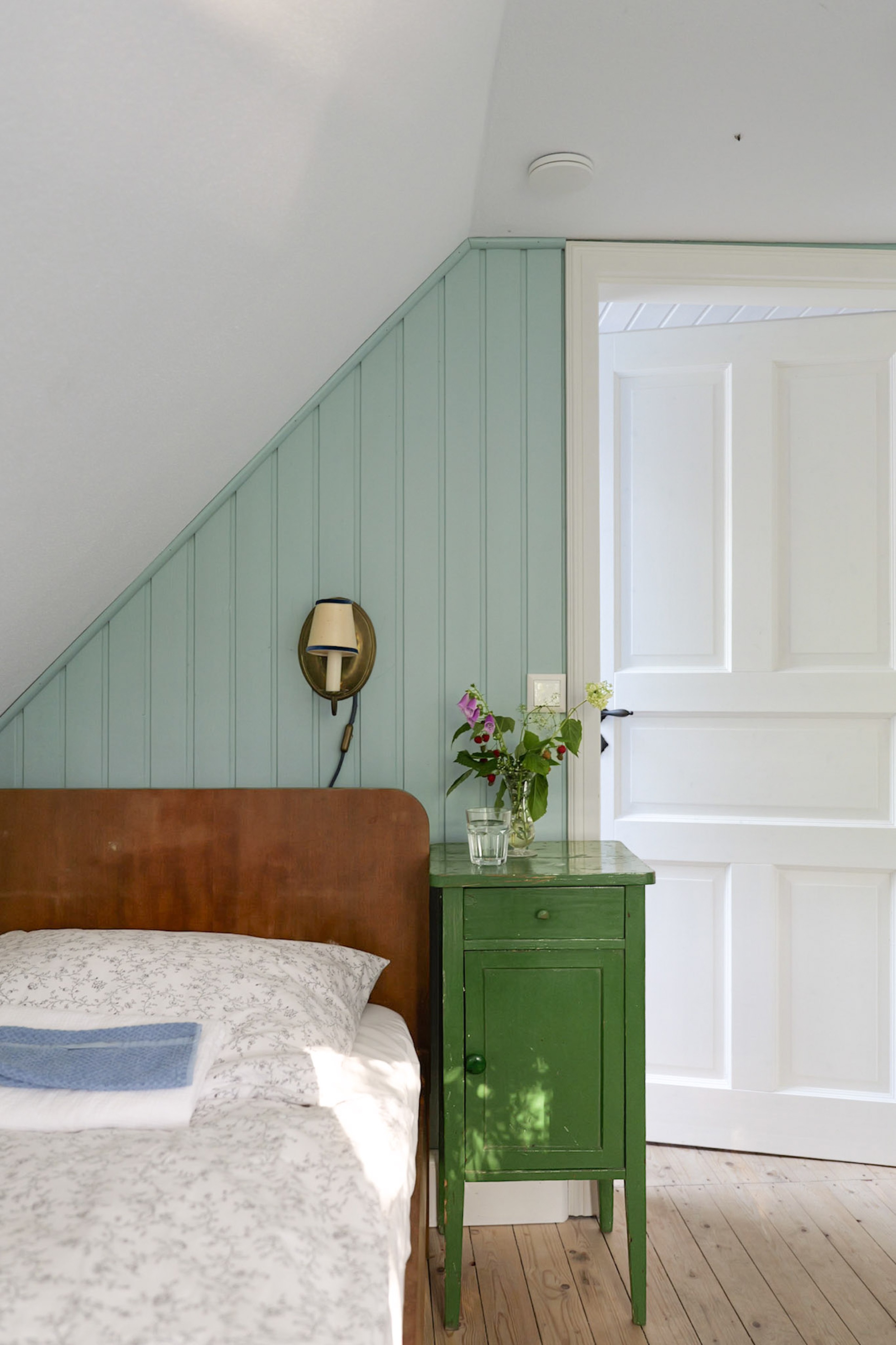 hexenhaus-nachttisch-im-schlafzimmer-mit-gruener-kommode