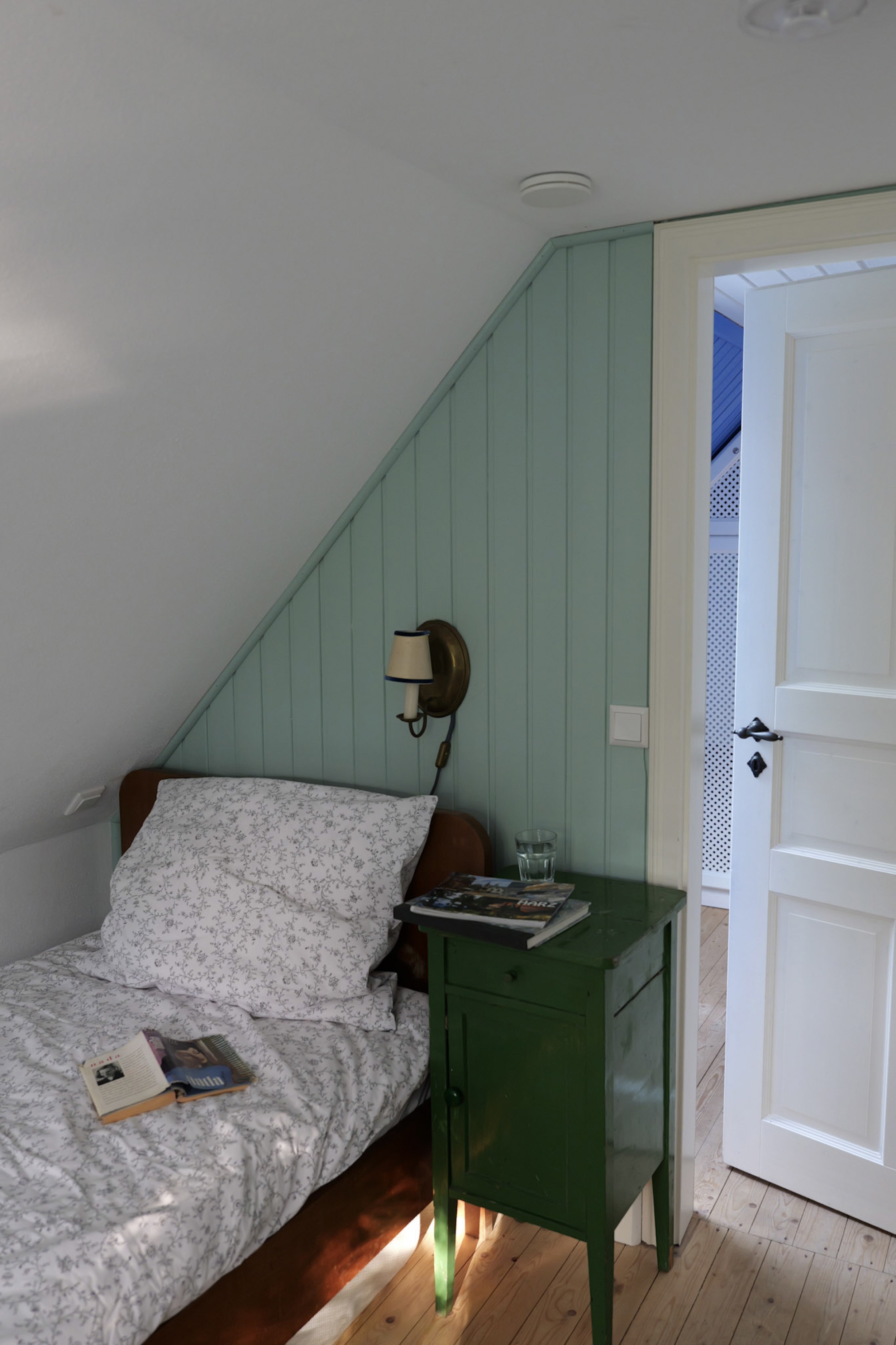 hexenhaus-nachttisch-mit-blick-durch-offene-tuer-auf-gitterschrank
