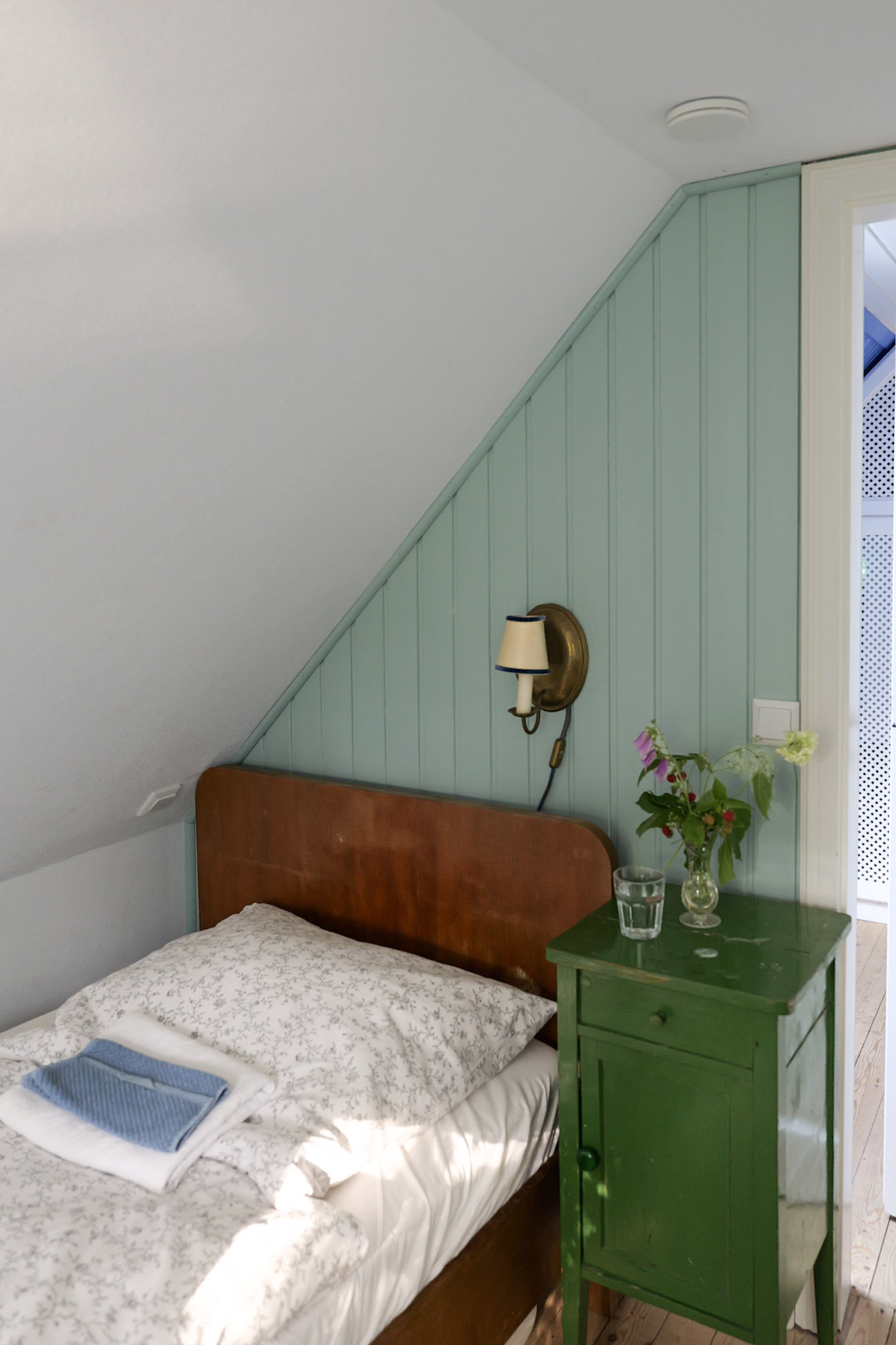hexenhaus-nachttisch-mit-blumenstrauss-tuer-einen-spalt-offen-zur-veranda