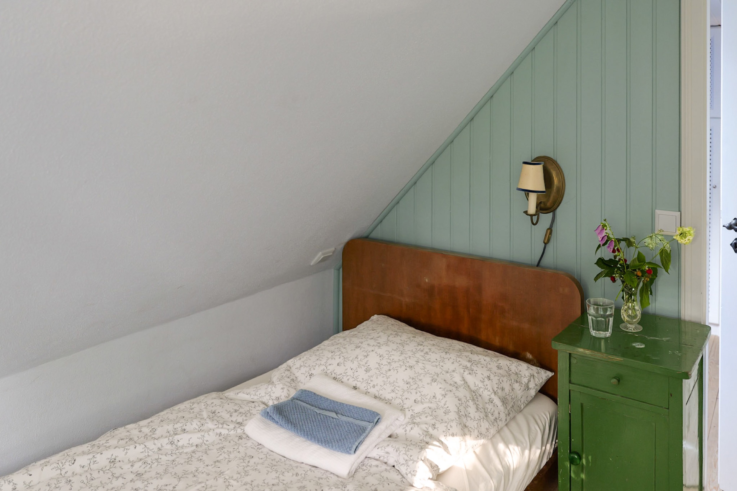 hexenhaus nachttisch mit blumenstrauss und handtuch nahaufnahme