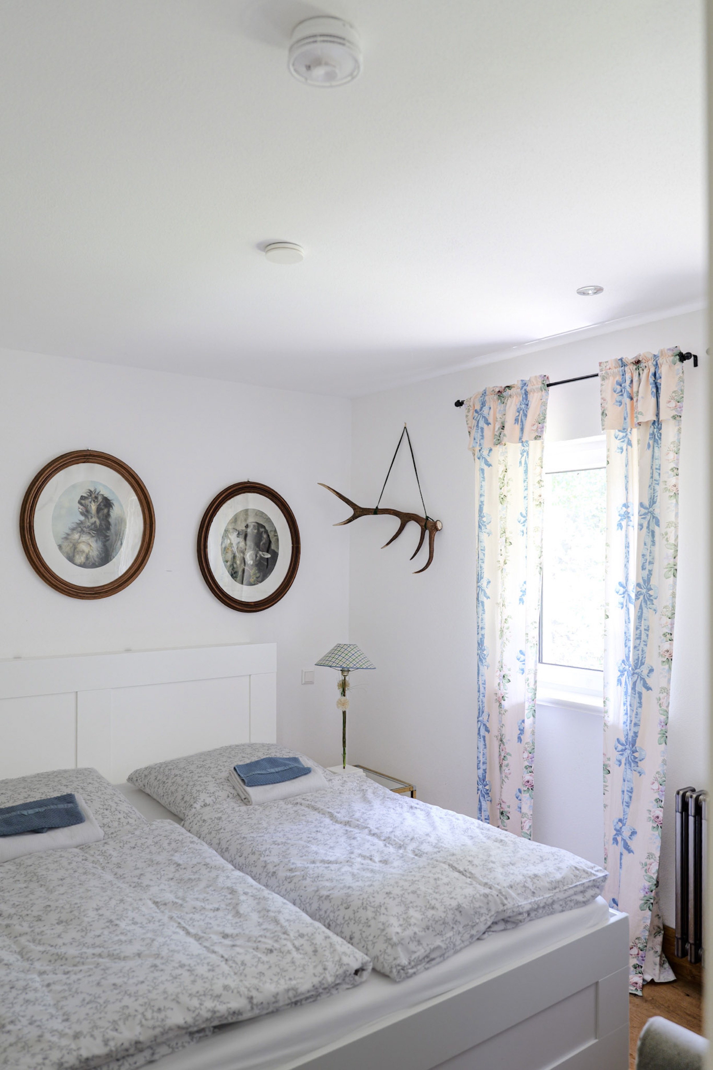 hexenhaus-schlafzimmer-mit-geweih-und-blumenvorhang