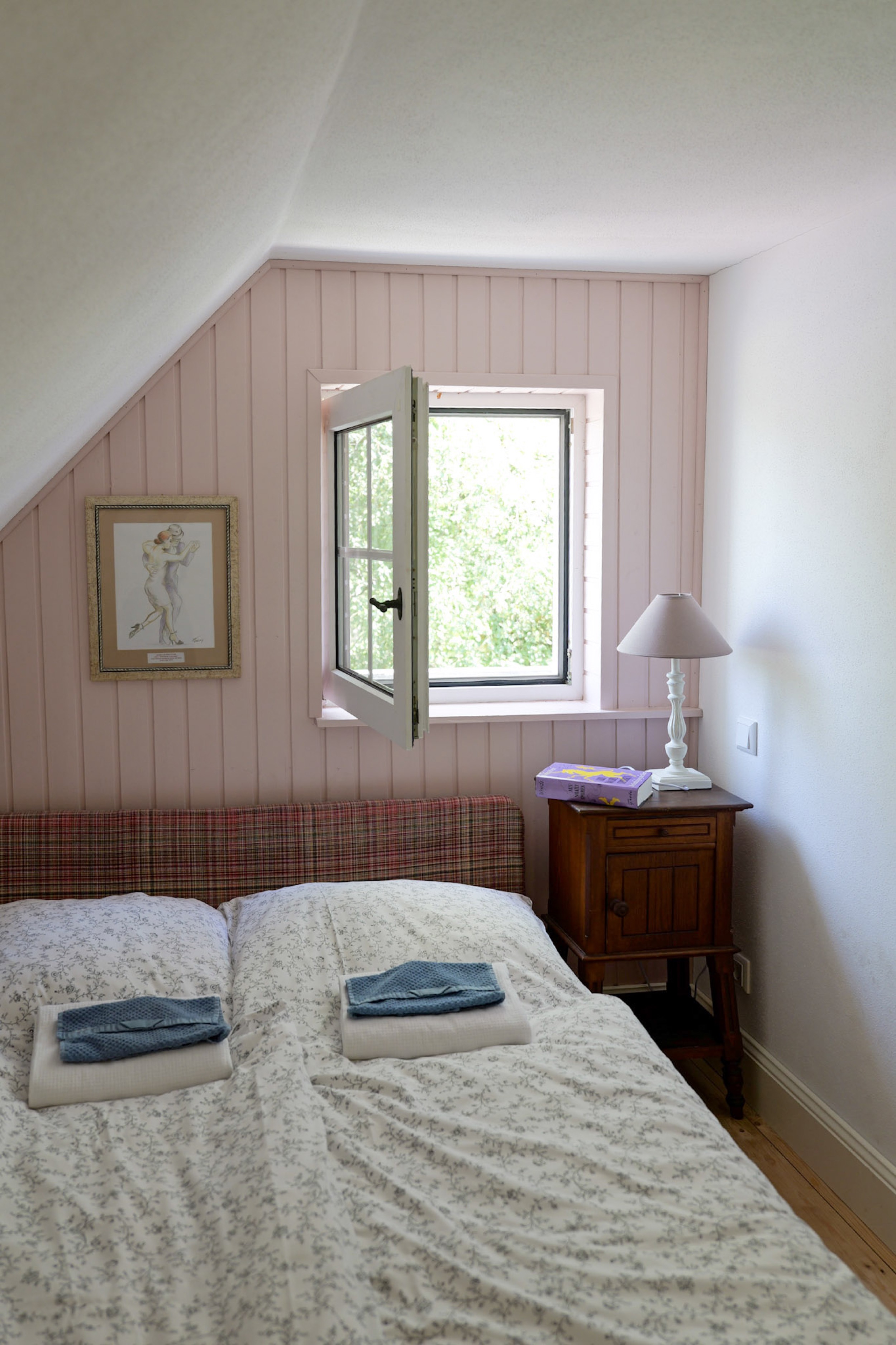 hexenhaus-schlafzimmer-mit-kariertem-kopfteil-und-blick-durchs-fenster