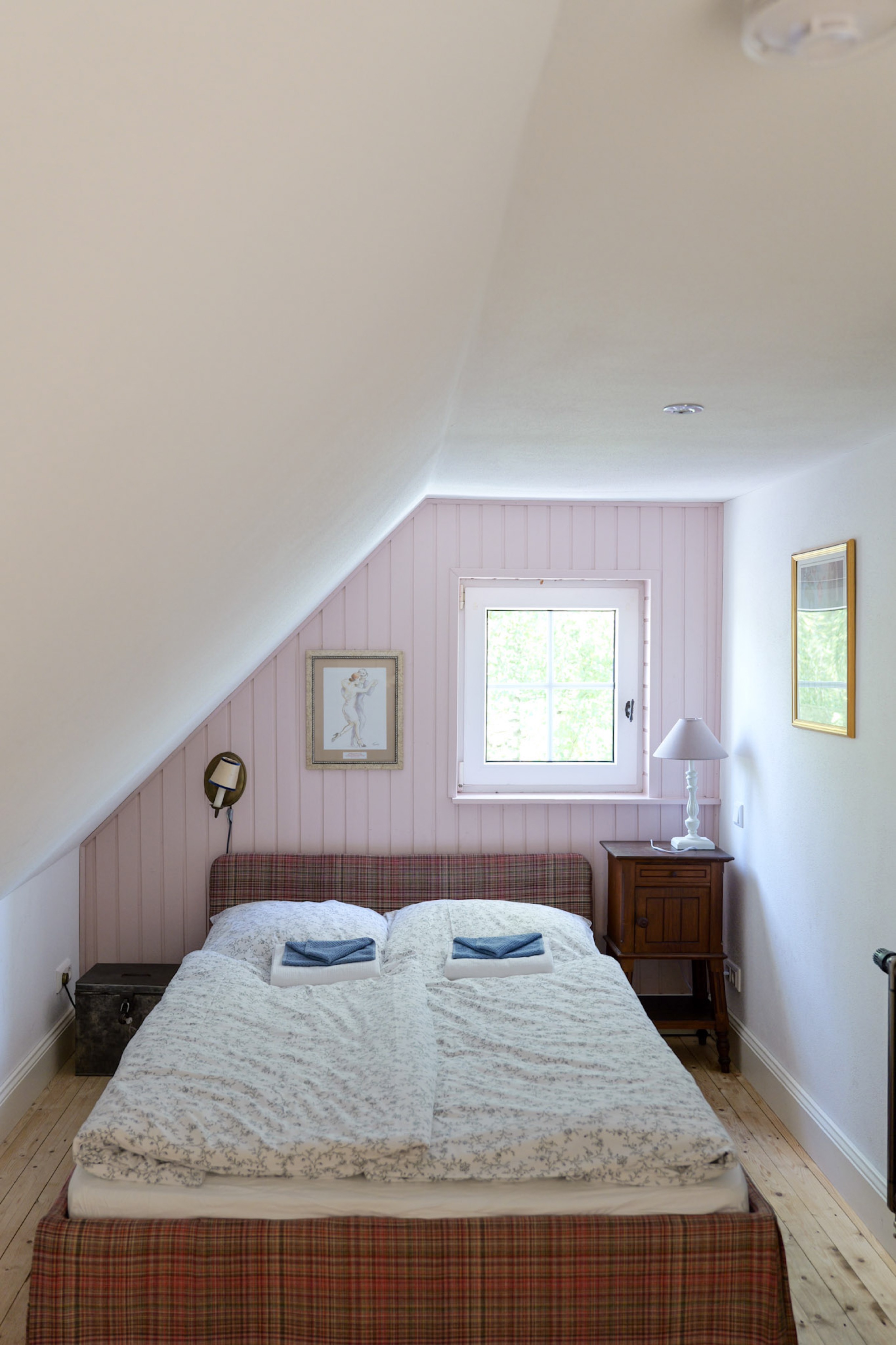 hexenhaus-schlafzimmer-mit-kariertem-polsterbett-und-blick-ins-gruene