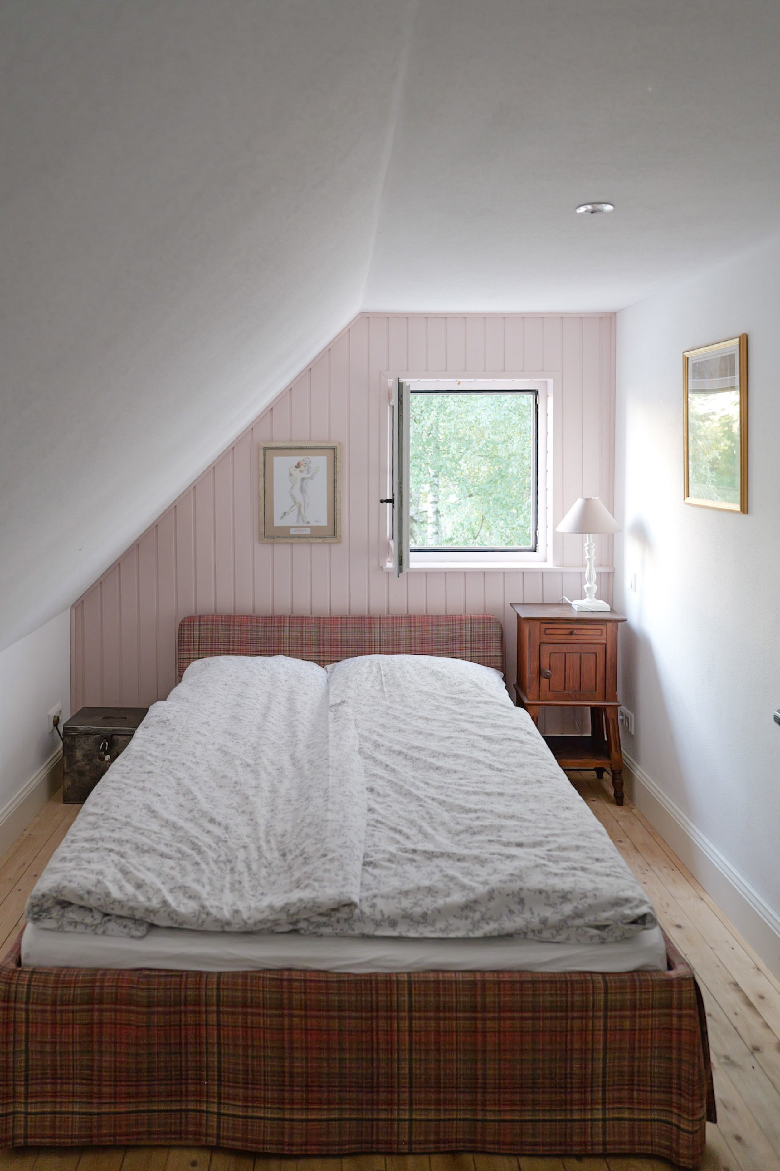 hexenhaus-schlafzimmer-mit-rosa-wandvertaefelung-und-karierter-bettwaesche