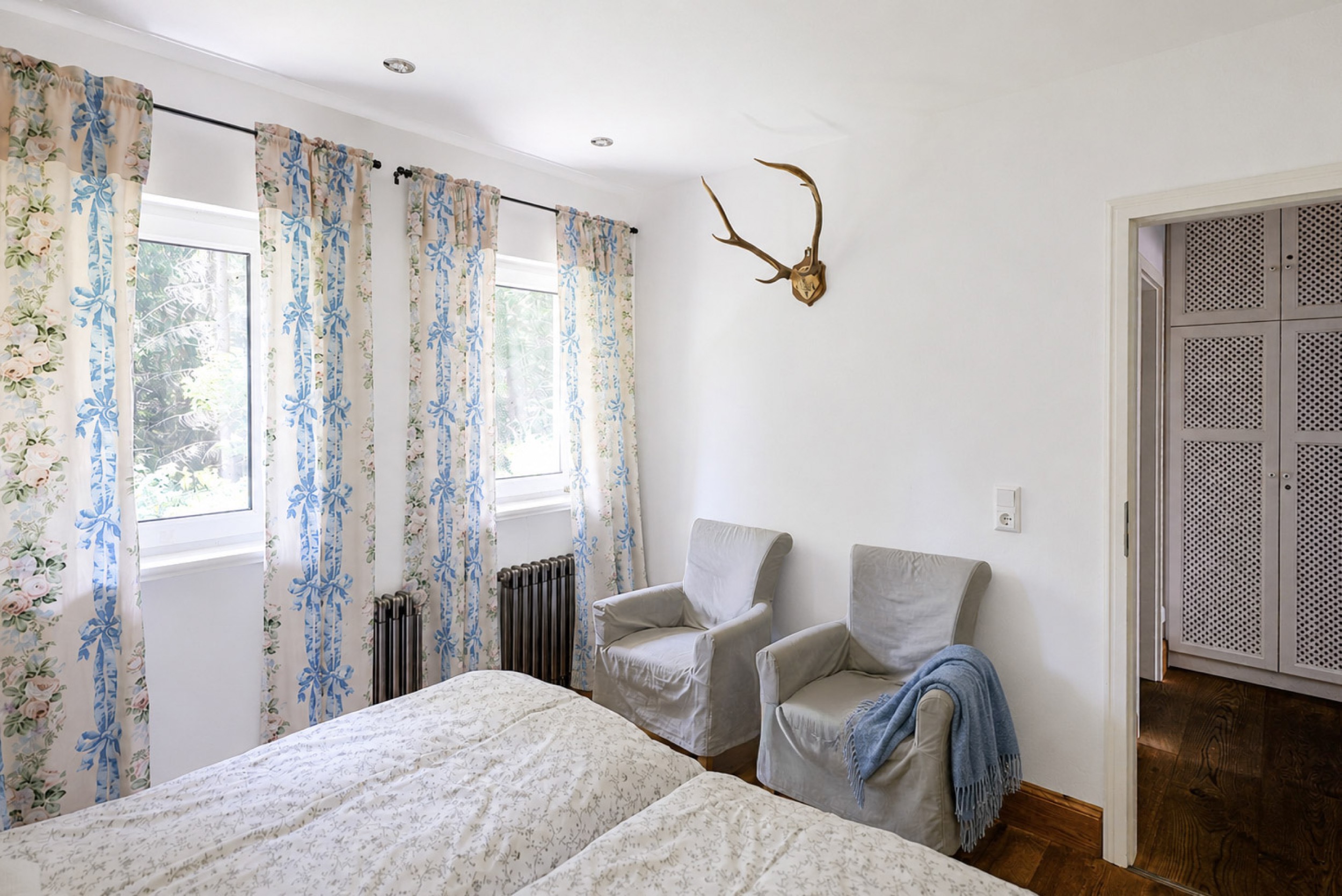 hexenhaus schlafzimmer unten mit geweih und sesseln blick zum schrank