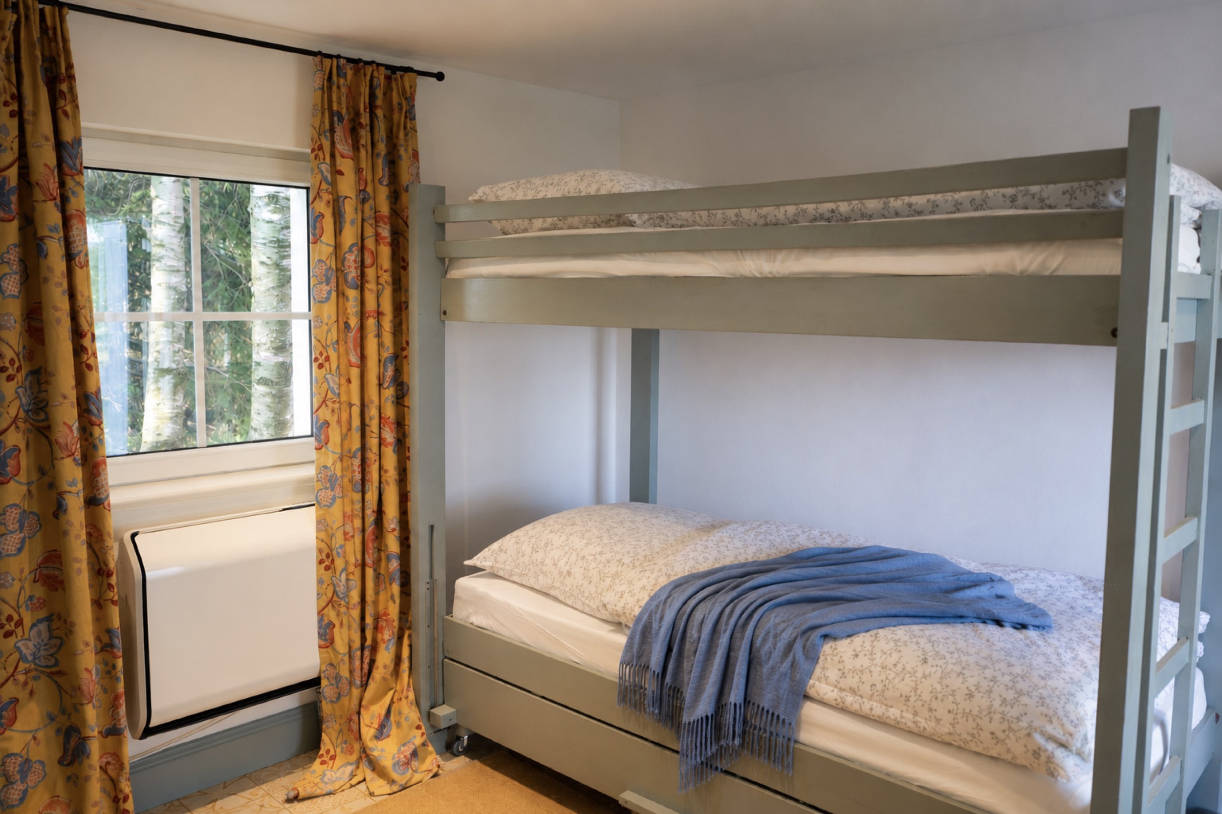 puppenhaus etagenbett mit blauer decke vor blumengardine