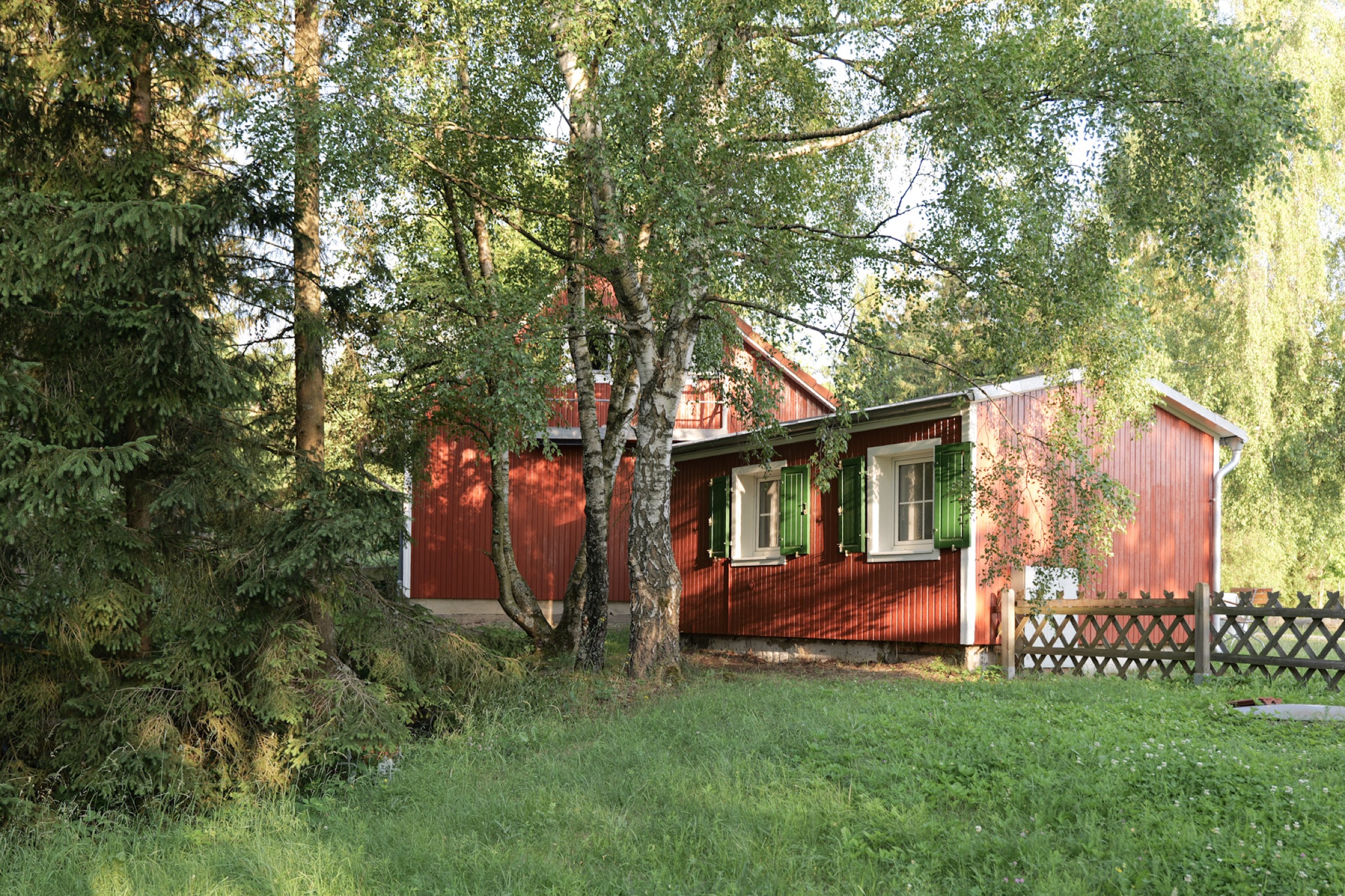 puppenhaus rotes haus mit giebel und birkenstamm im vordergrund