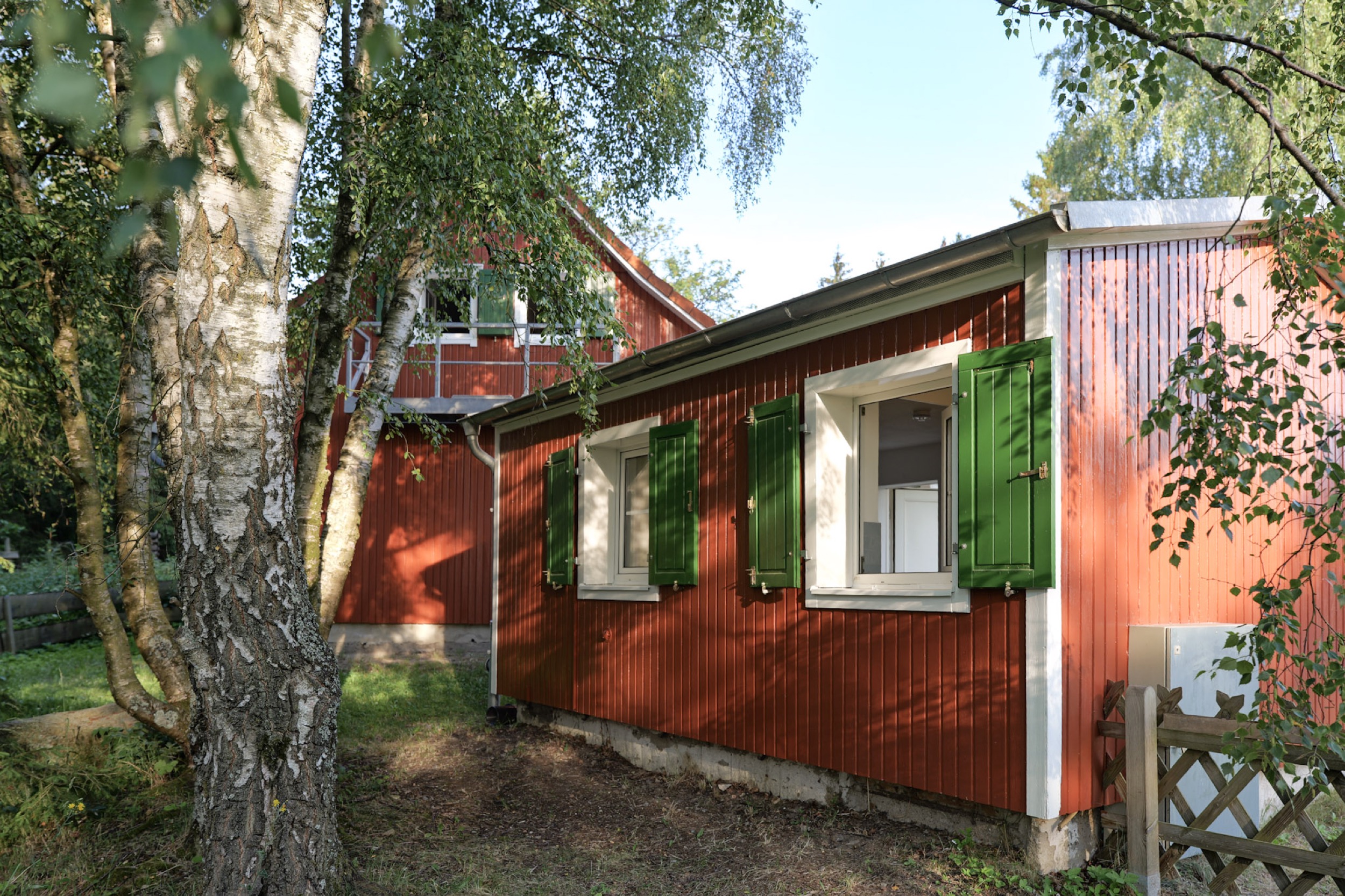 puppenhaus rotes haus mit zwei gruenen fensterlaeden am anbau